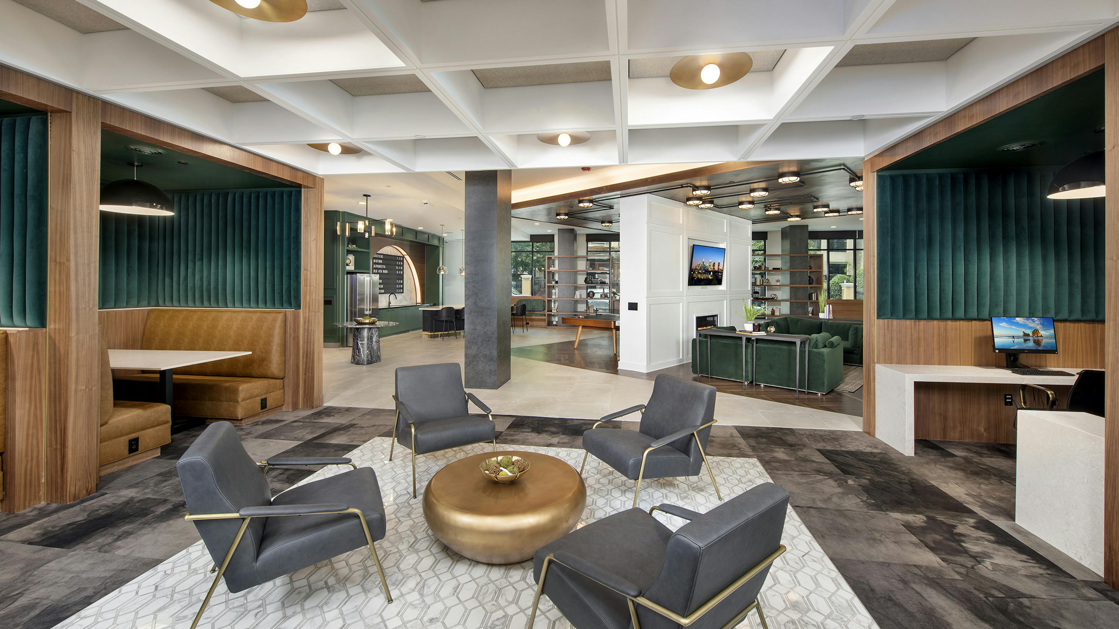 AMLI Flatiron clubhouse with grey chairs and gold coffee table with tan and green banquet seating and coffered ceiling