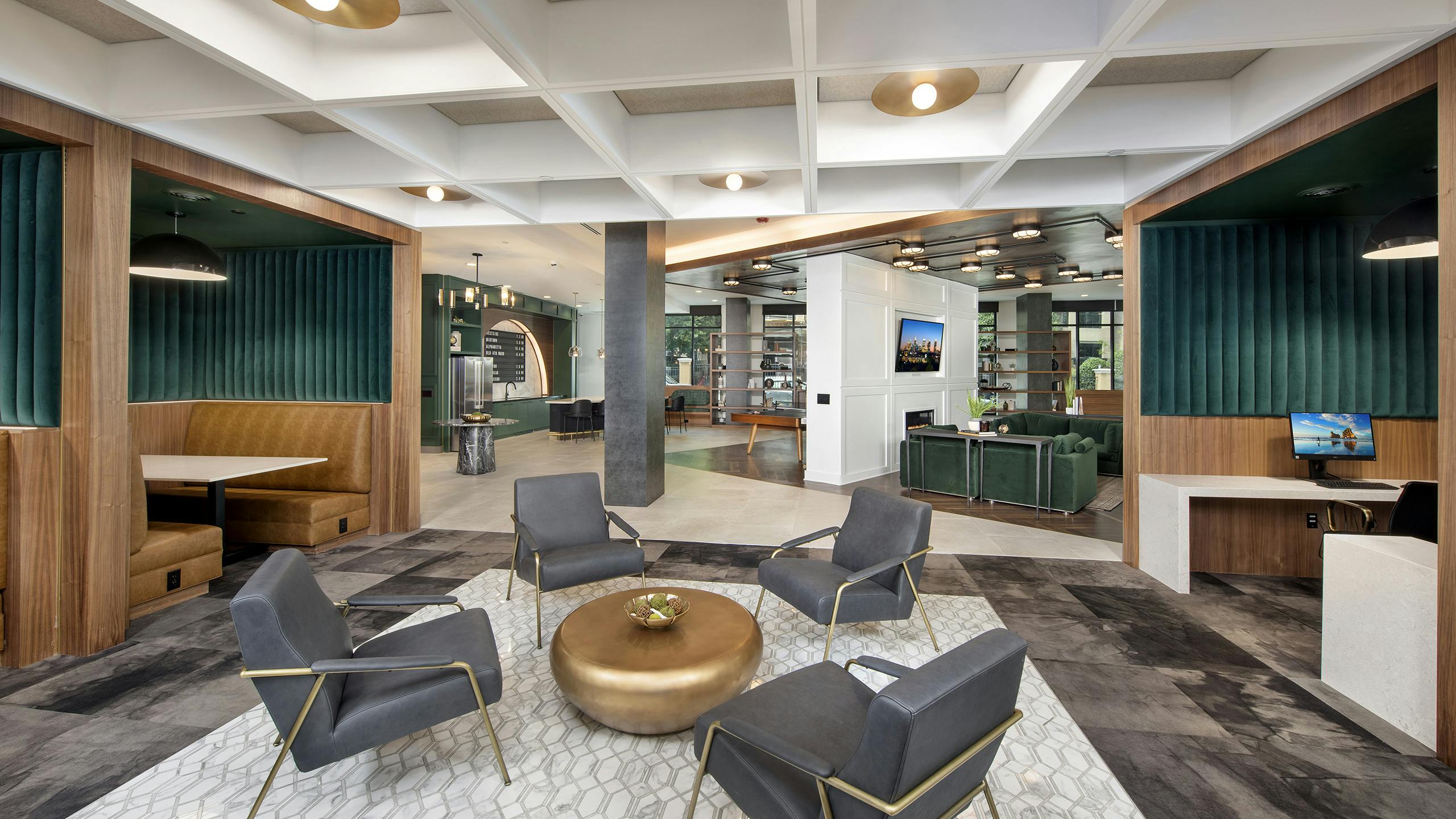 AMLI Flatiron clubhouse with grey chairs and gold coffee table with tan and green banquet seating and coffered ceiling