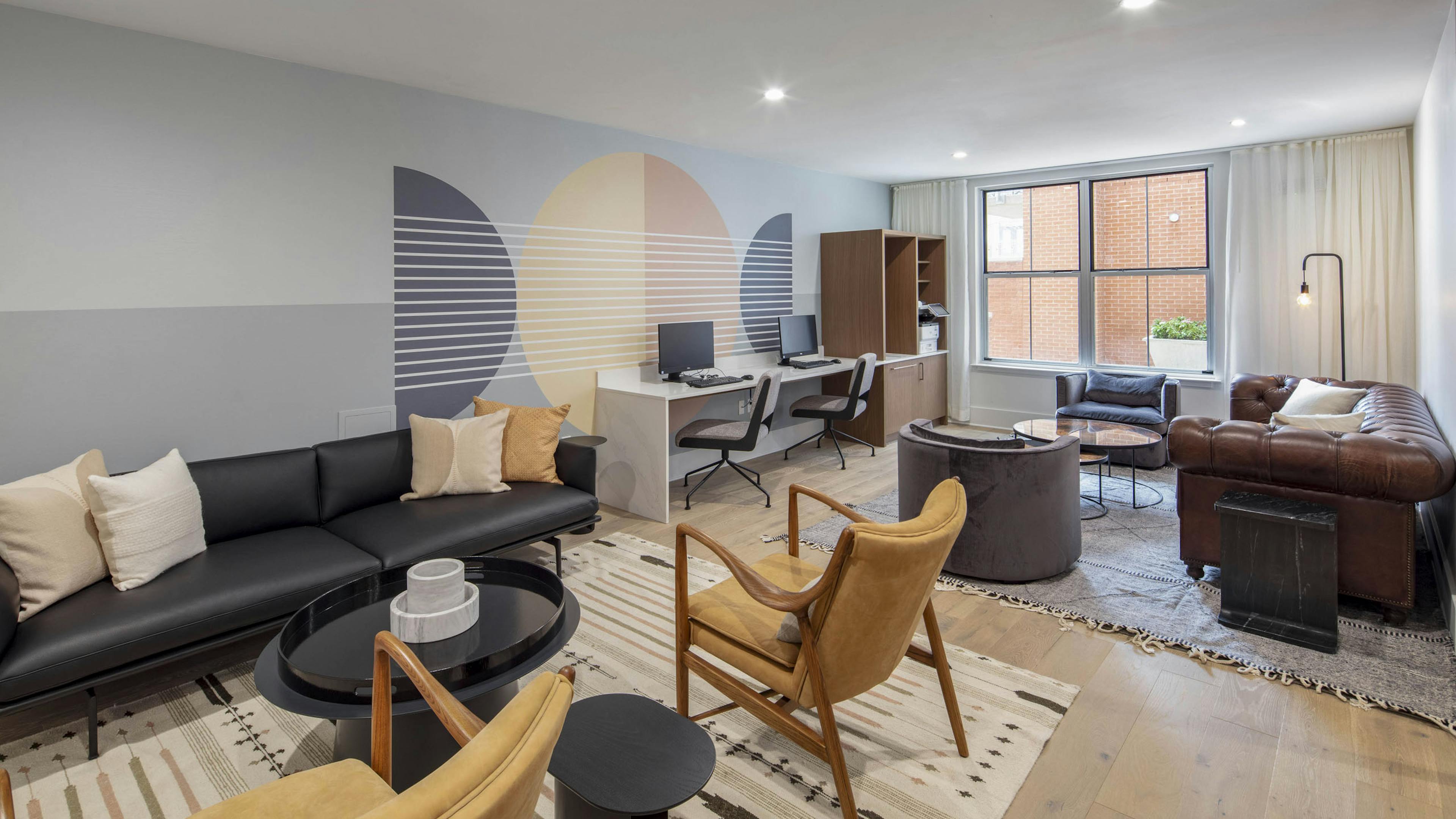 Business center at AMLI Downtown apartments with two computer stations and printer and 2 leather seating areas on area rugs