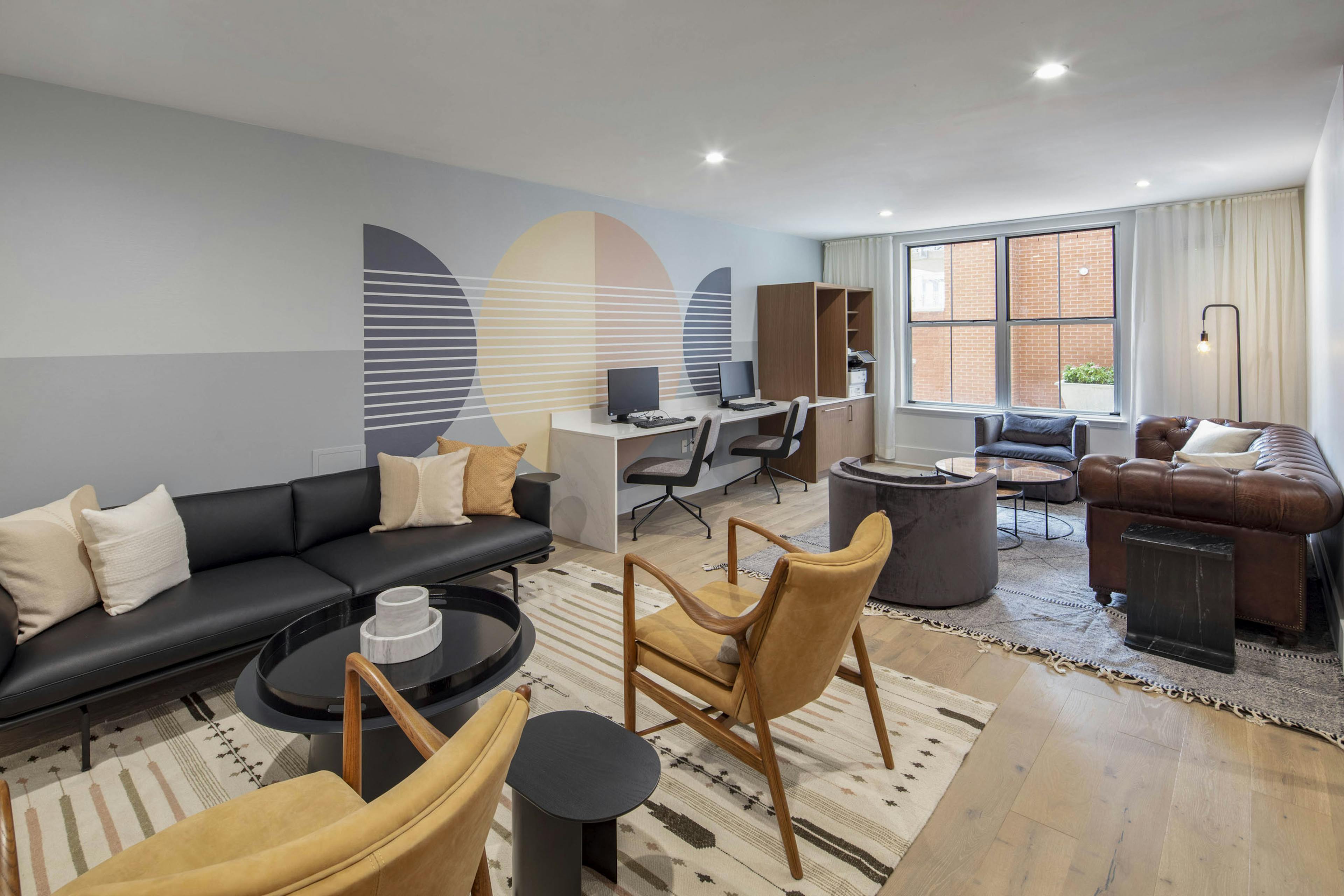 Business center at AMLI Downtown apartments with two computer stations and printer and 2 leather seating areas on area rugs