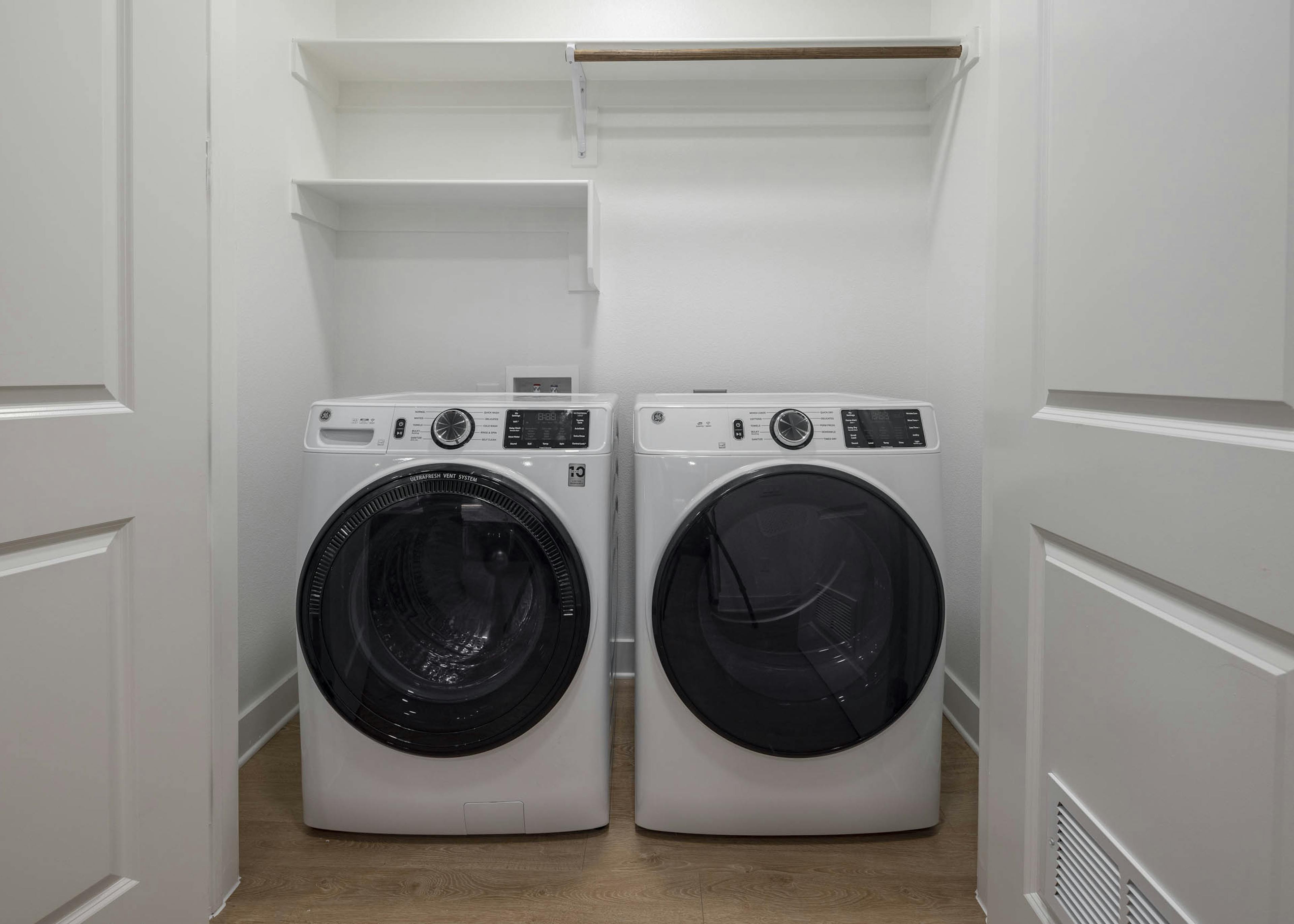 Close up interior view of modern in unit laundry machines tucked away in spacious AMLI Branch Park apartment closet