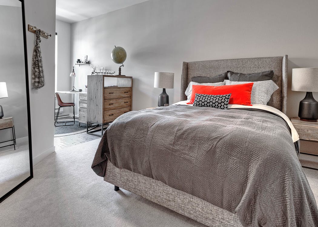 Apartment bedroom at AMLI South Lake Union with a queen-sized bed and bedside table with a lamp and view of the walk in closet