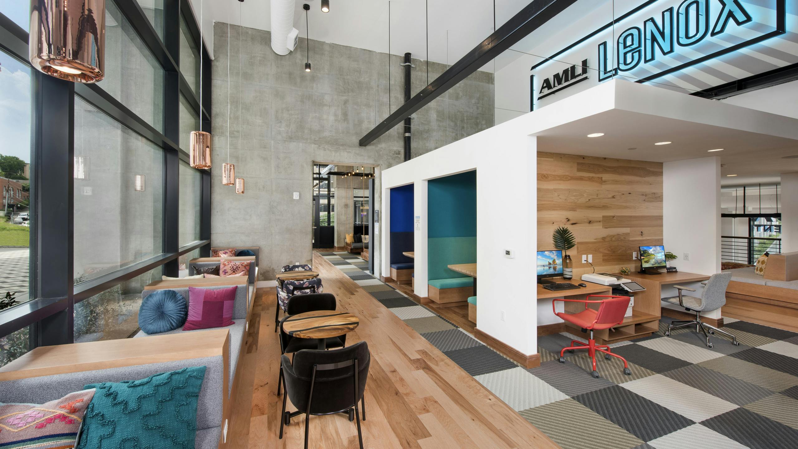AMLI Lenox coworking space with computer stations and seating areas with colorful pillows and floor to ceiling windows
