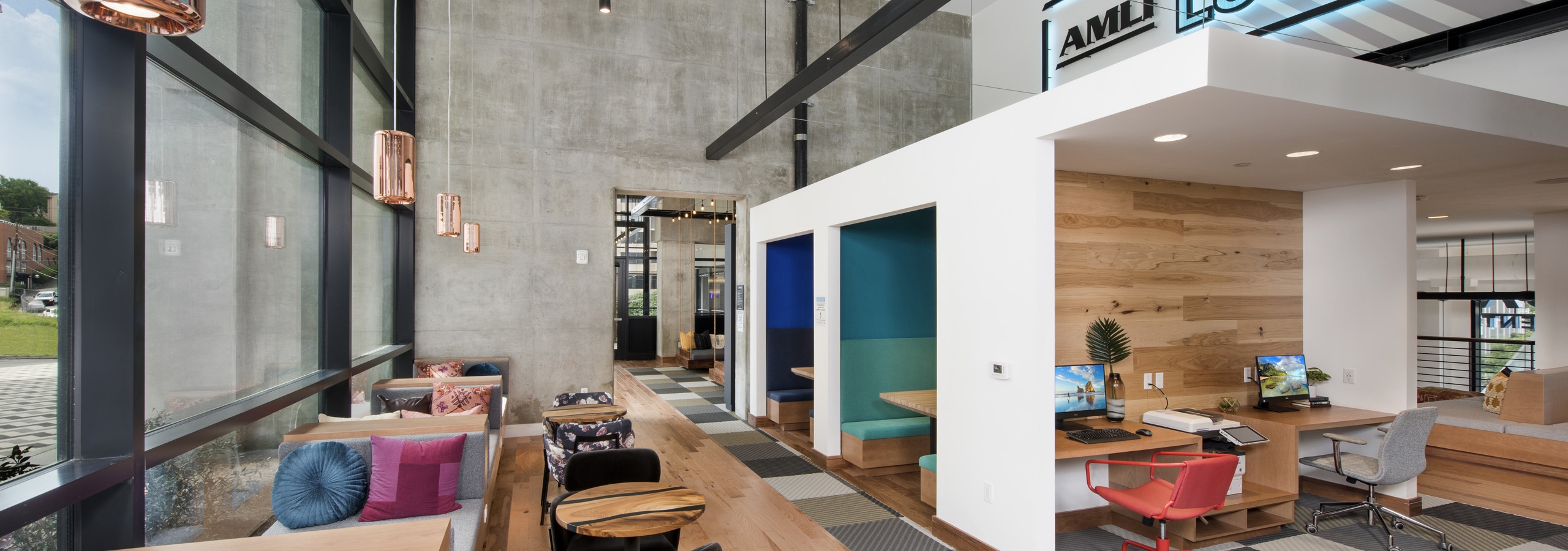 AMLI Lenox coworking space with computer stations and seating areas with colorful pillows and floor to ceiling windows