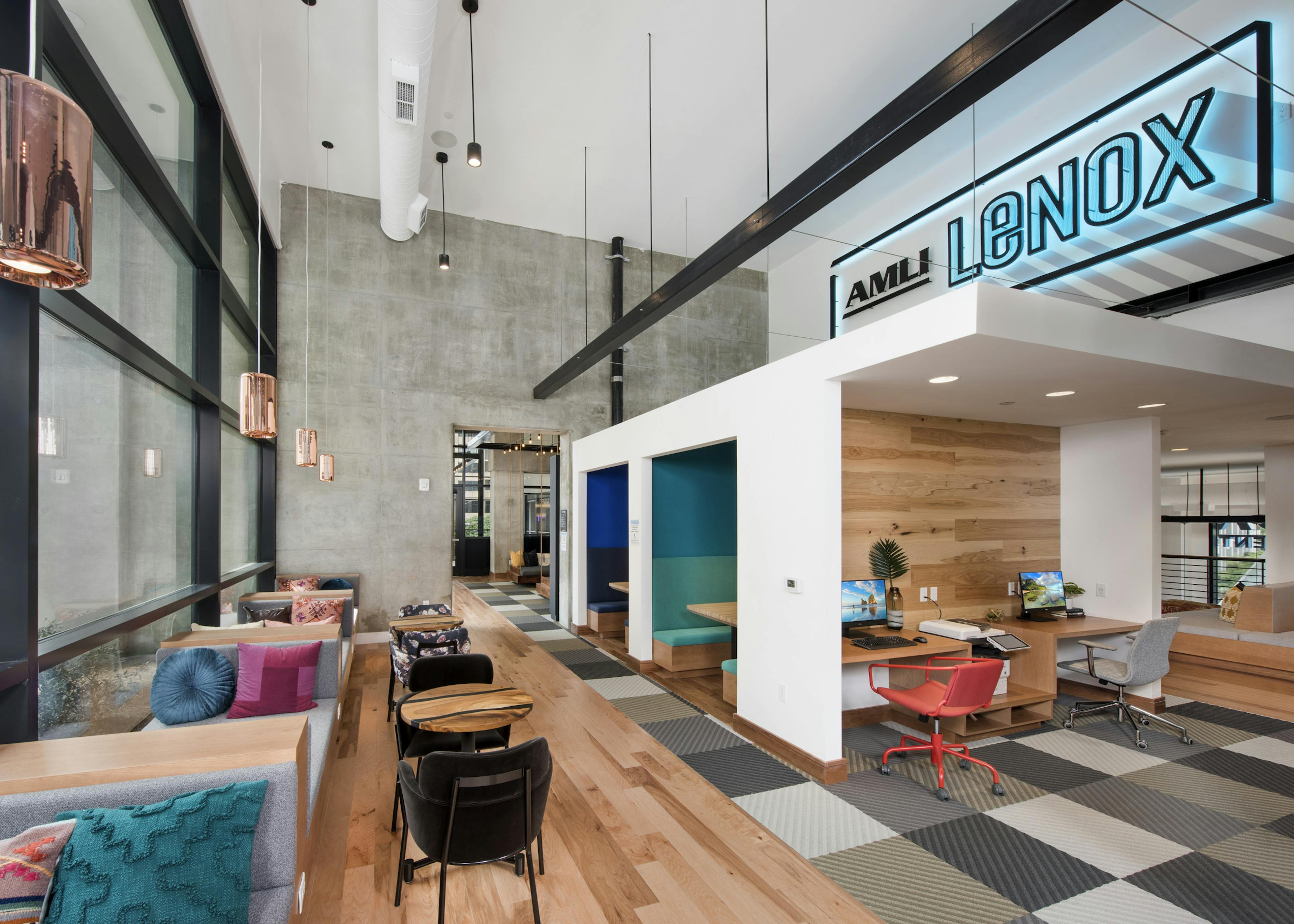 AMLI Lenox coworking space with computer stations and seating areas with colorful pillows and floor to ceiling windows 