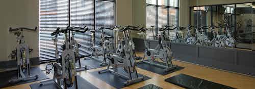 Interior of the spinning room at AMLI Old 4th Ward with one wall full of mirrors and another with large windows for sunlight