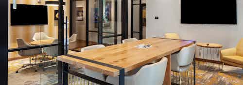 Business center at AMLI Riverfront Green apartments with multiple tables and chairs and a separate conference room area