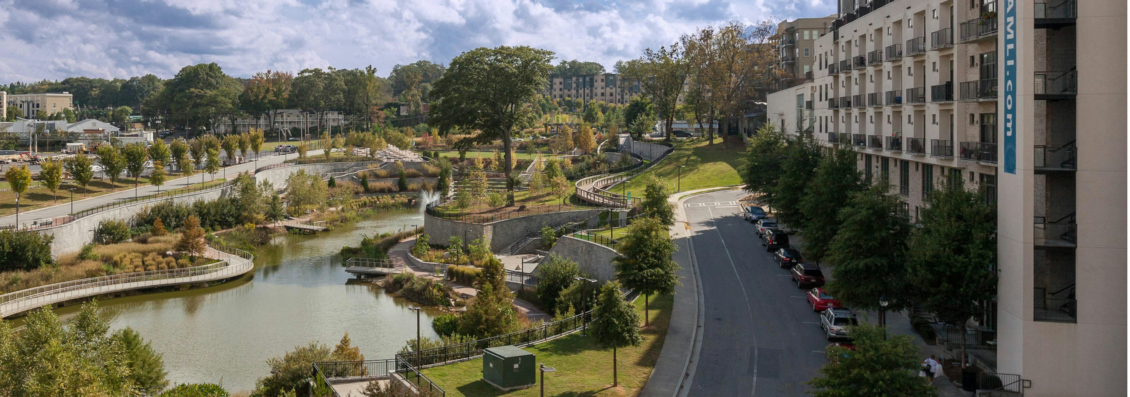 View of AMLI Ponce Park just steps away from Historic Old 4th Ward Park with luscious landscaping and walkways with a pond