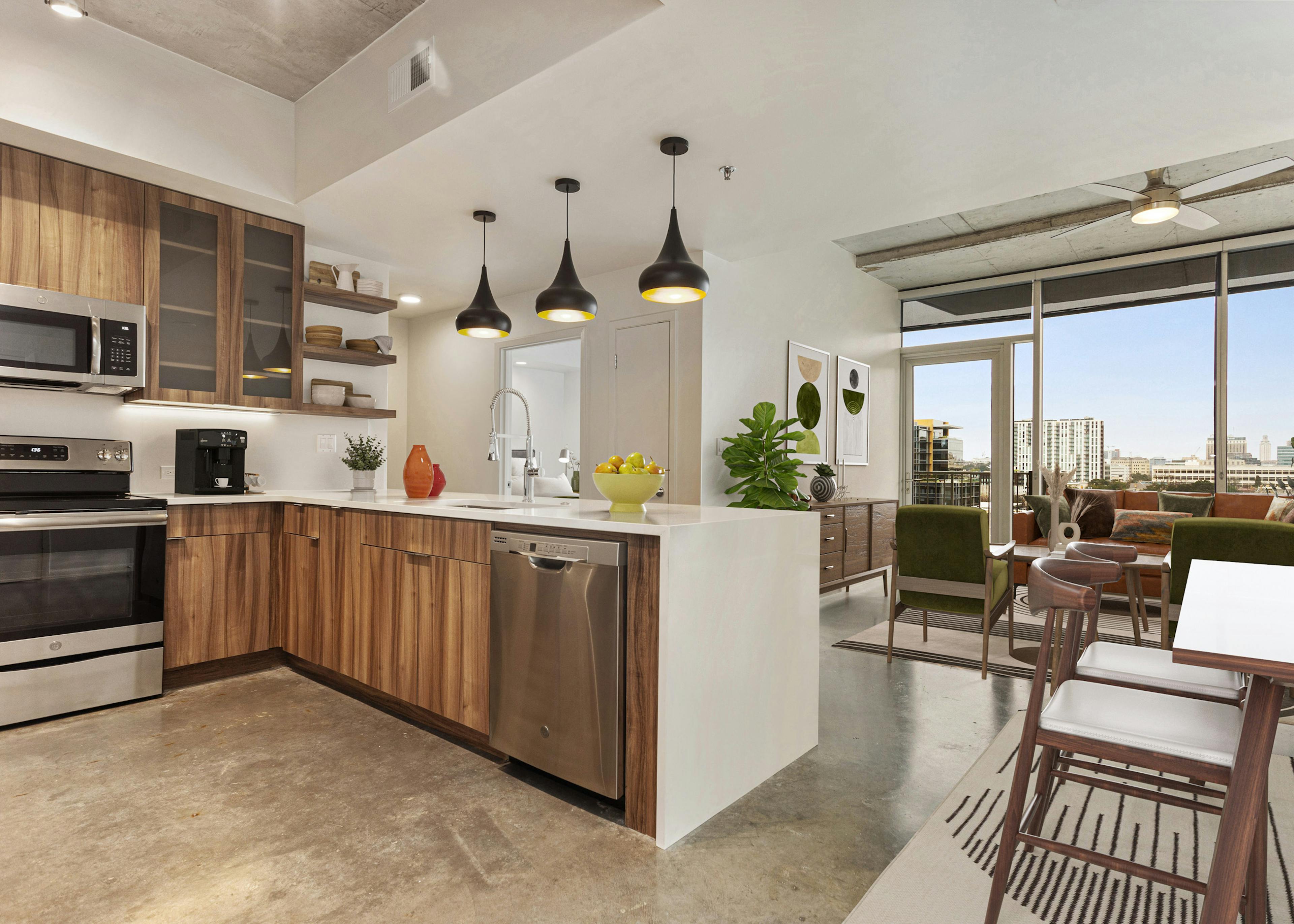 AMLI on 2ND kitchen with wood grain cabinets and 3 pendant lights adjacent to living room with floor to ceiling windows 