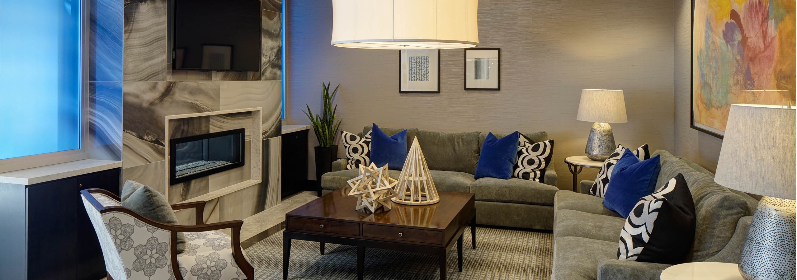 Resident lounge at AMLI Deerfield with a marble fireplace and large TV with various couch and chair seating options