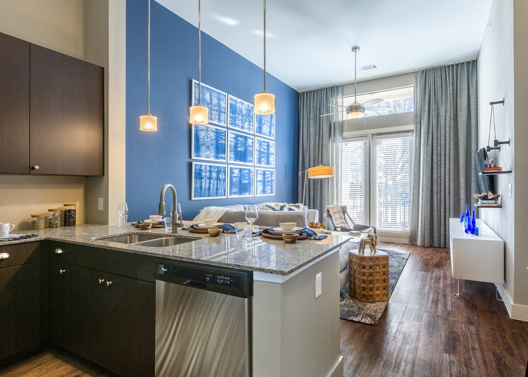 Interior of kitchen at AMLI on Riverside with spacious counter connecting to living space with tall glass balcony doors