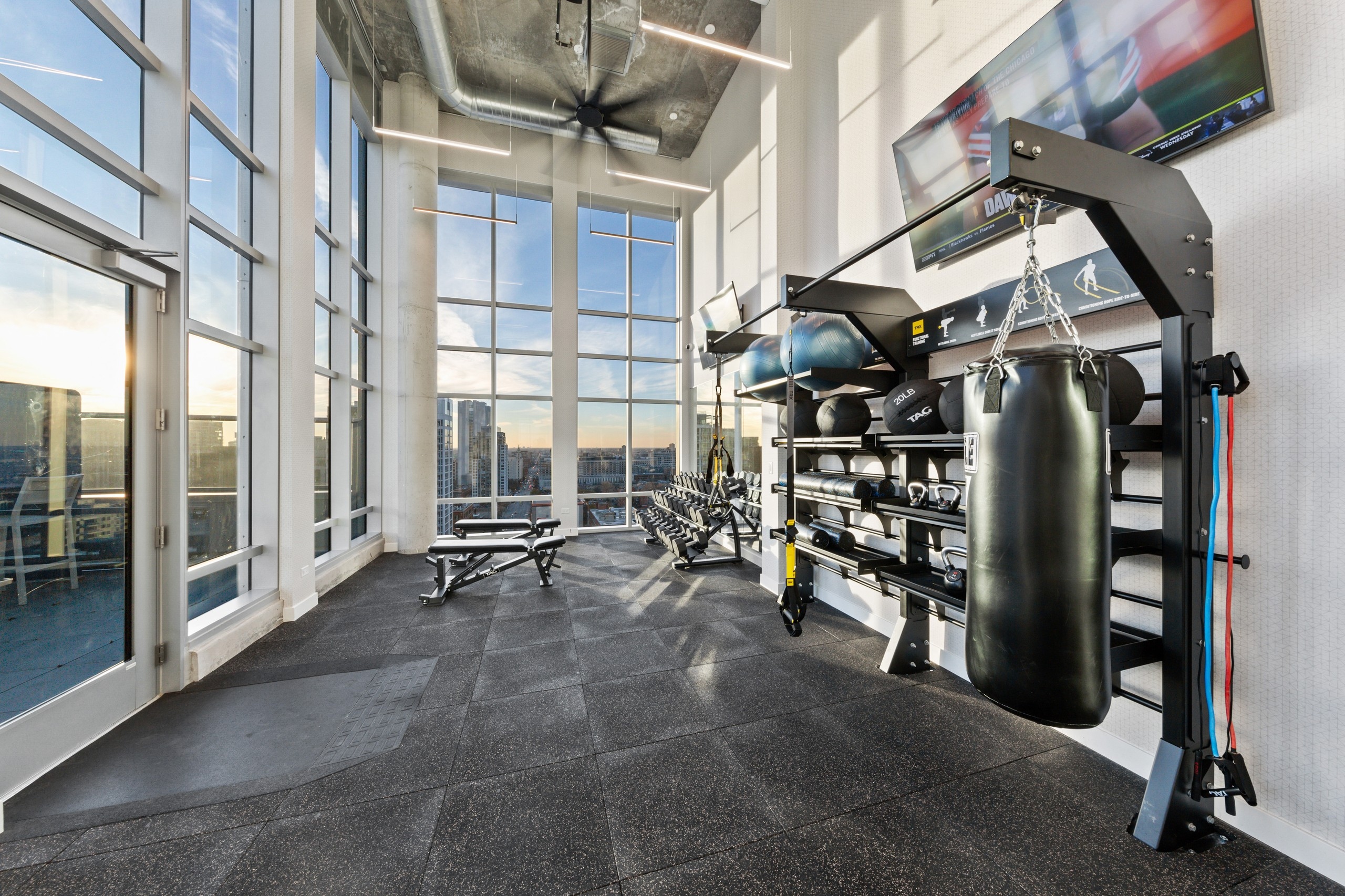 AMLI 808 fitness center with floor to ceiling windows featuring a dumbell rack as well as medicine balls and a boxing bag