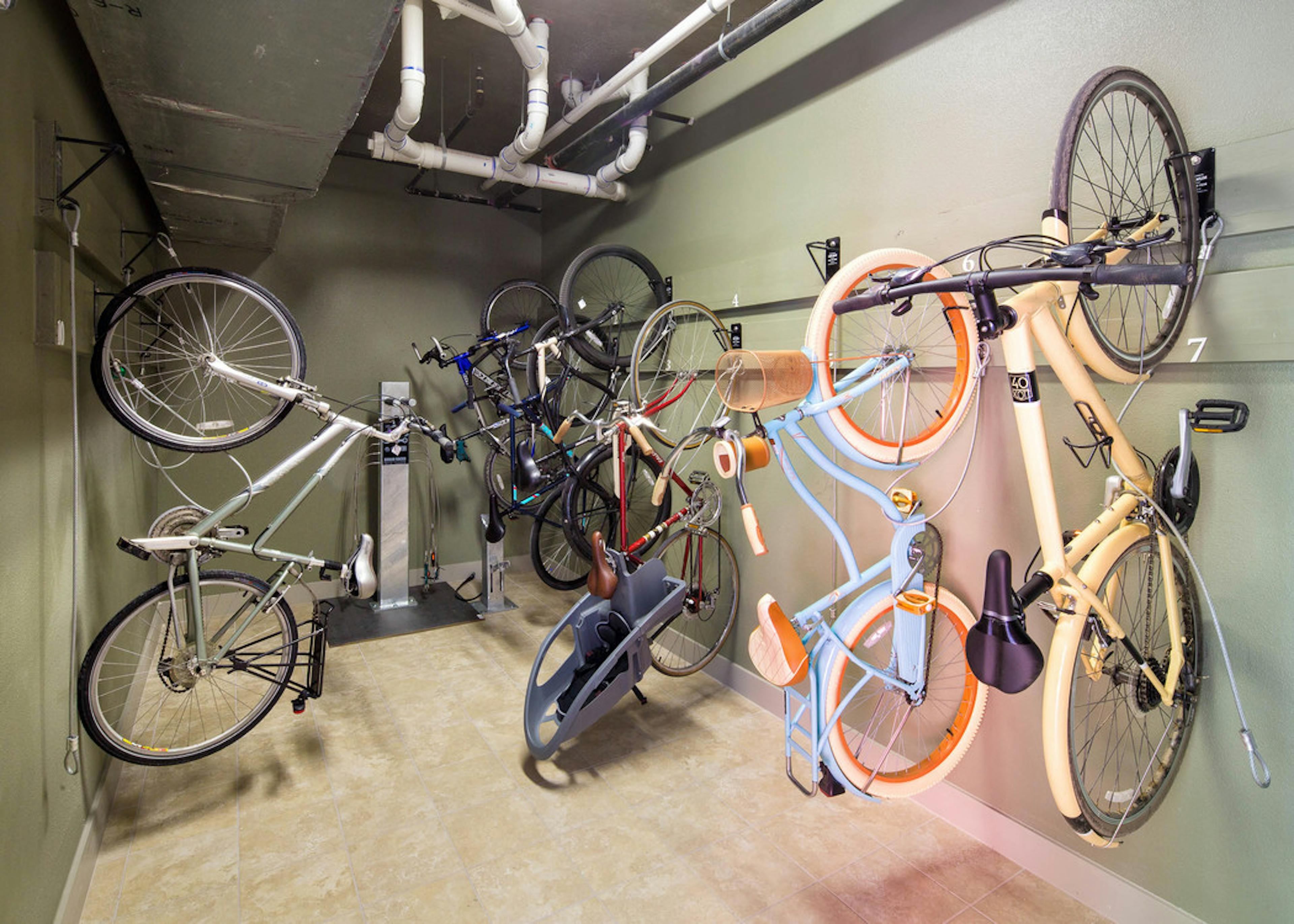 AMLI at Mueller bike repair room with bikes hanging vertically on the walls and a pump for filling wheels in the background