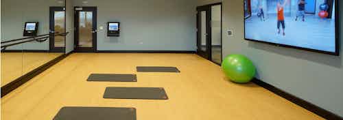 AMLI Deerfield yoga and pilates studio with fitness classes on demand on large screen including yoga mats and balls and barre