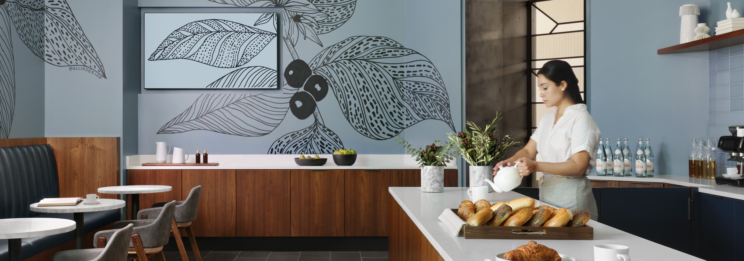 AMLI Fountain Place resident lounge with white serving counters on brown cabinets and tables and chairs and blue wallpaper