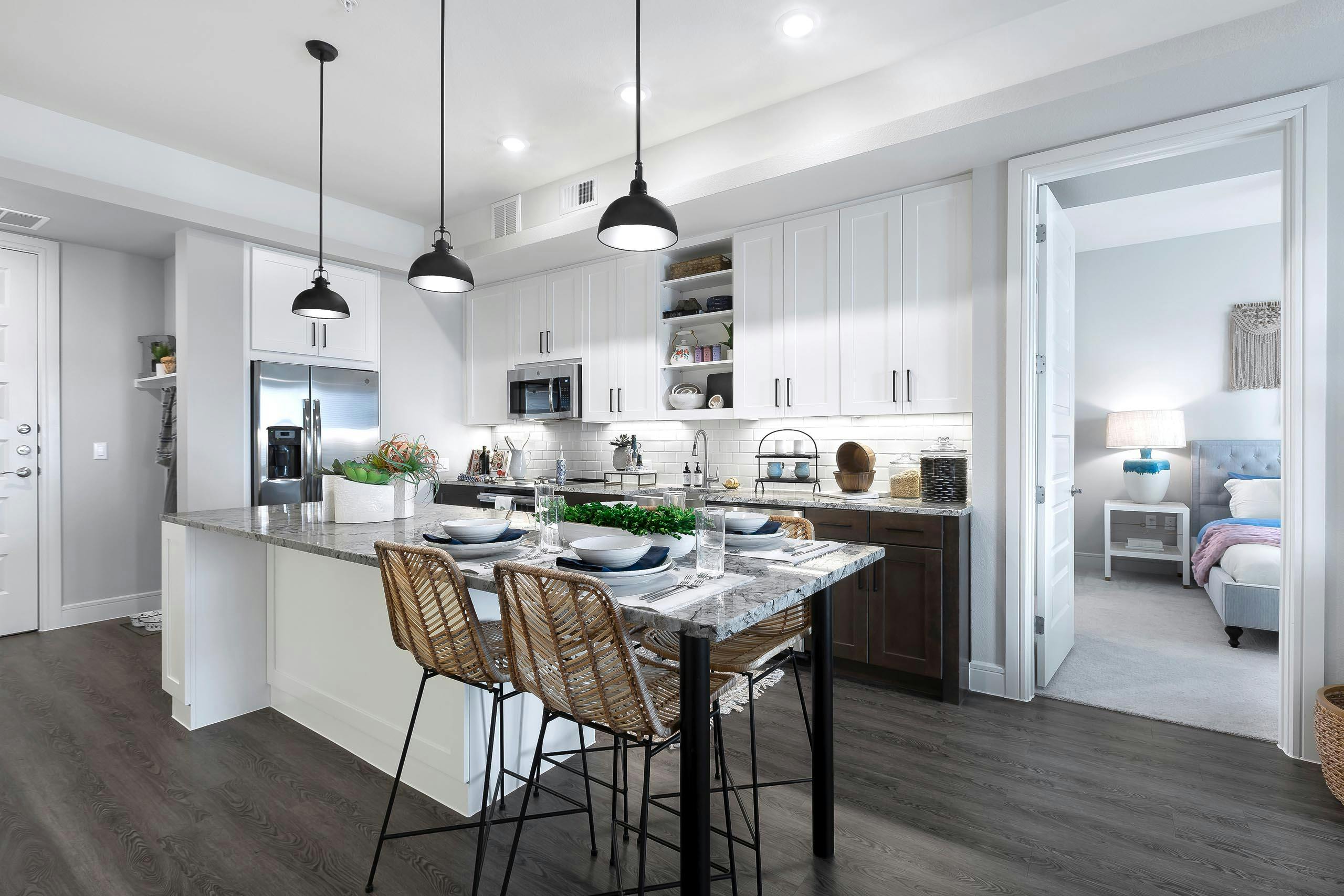 AMLI Lakeline apartment kitchen with stainless steel appliances and dining island with gray granite countertops