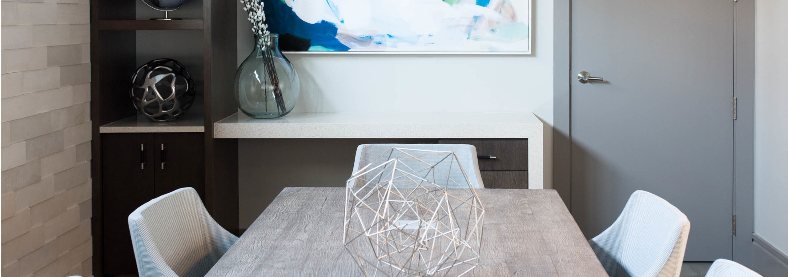 AMLI 3464 conference room with white chairs around a grey conference table with a dark wood shelf in the background