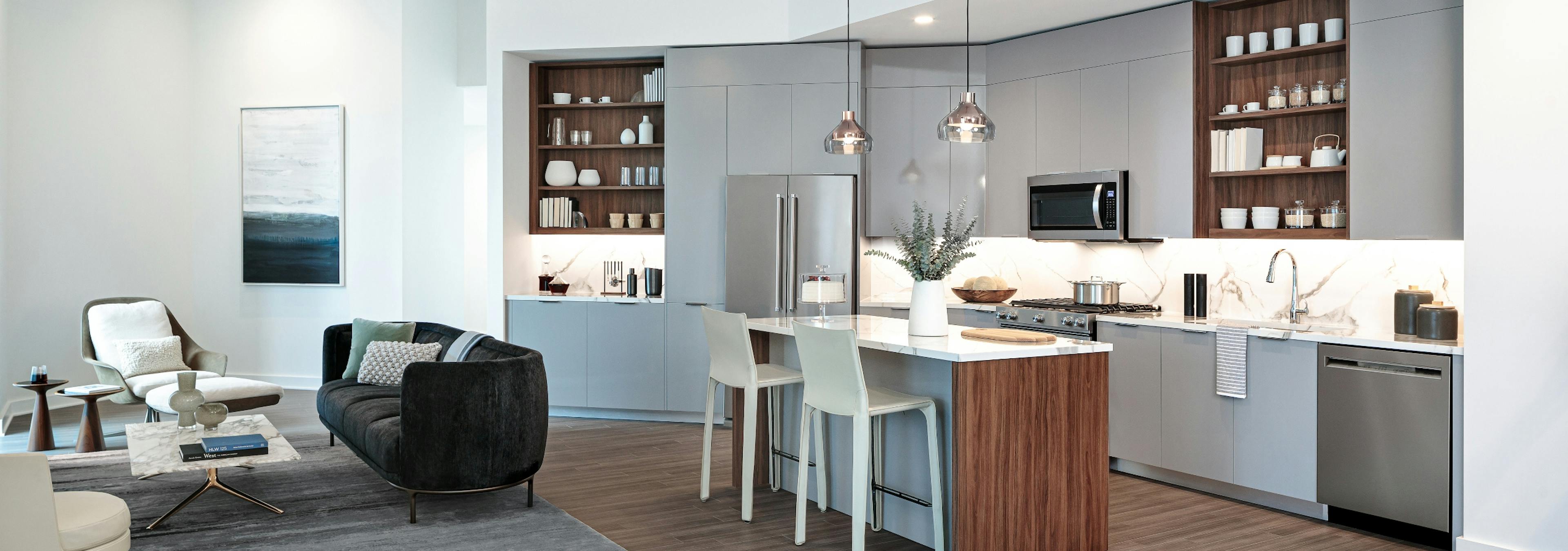 Interior view of AMLI Fountain Place European style kitchen with island and stainless steel appliances with light wood floors