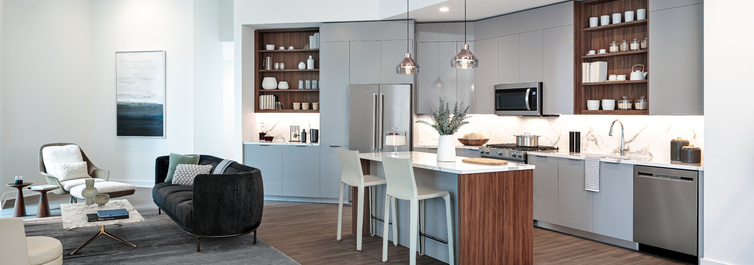 Interior view of AMLI Fountain Place European style kitchen with island and stainless steel appliances with light wood floors