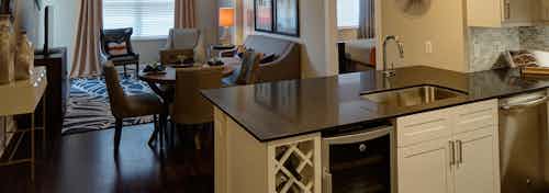 AMLI Deerfield open floorplan kitchen and living room featuring large dark countertop island and beverage refrigerator