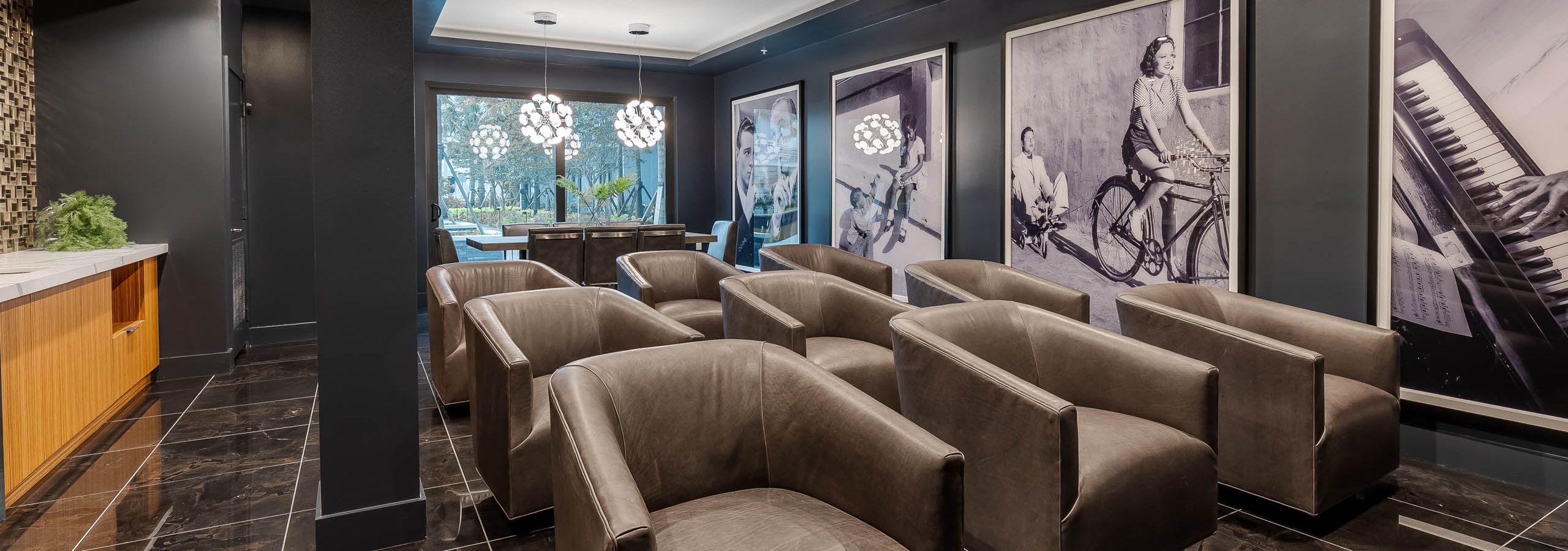 The media theatre at AMLI Park West apartments with leather armchairs and large black and white wall photos and chandeliers