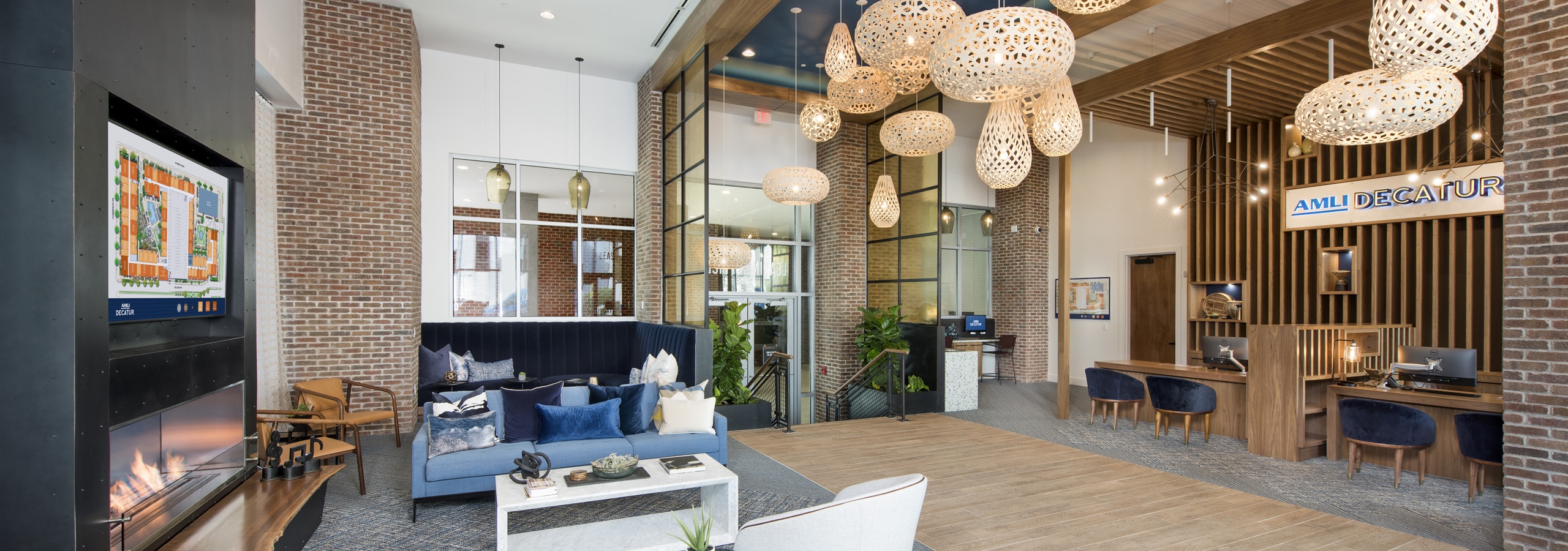 AMLI Decatur leasing office with fireplace and comfortable seating with floating decorative light fixtures and leasing desks