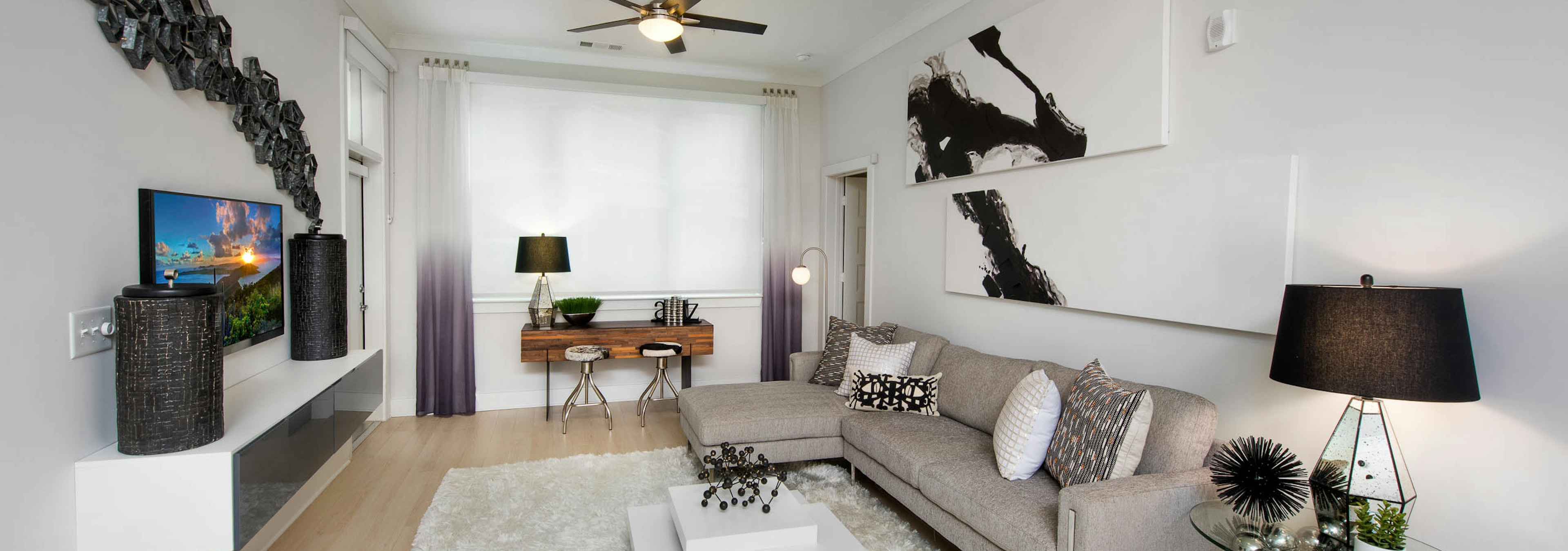 Alternate angle of AMLI Buckhead living room with black, white and beige color scheme with creme walls and light wood floors