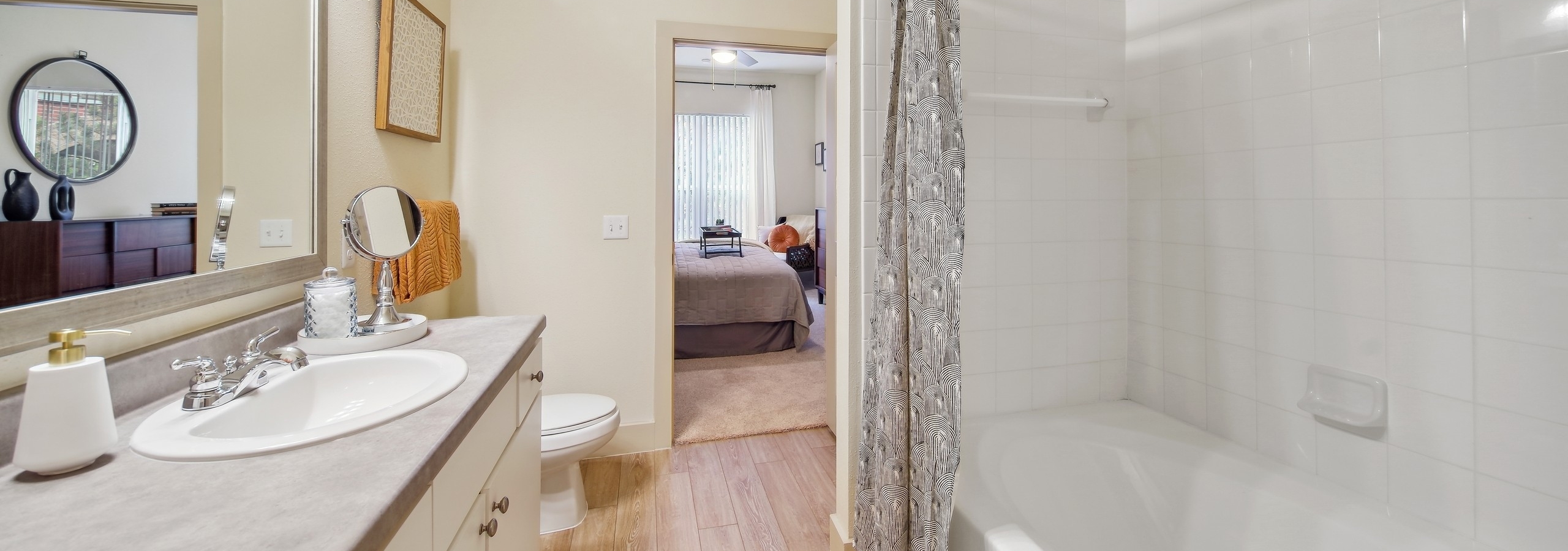 AMLI Park Avenue bathroom showcasing a garden tub and sink with a large vanity countertop space and a view into a bedroom