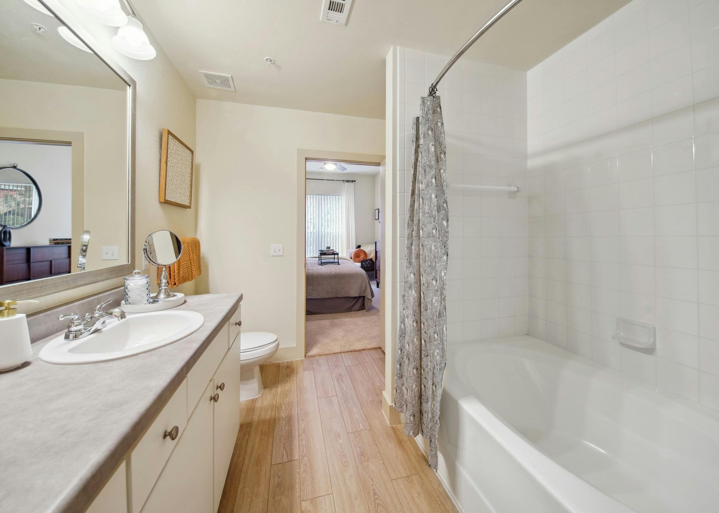 AMLI Park Avenue bathroom showcasing a garden tub and sink with a large vanity countertop space and a view into a bedroom