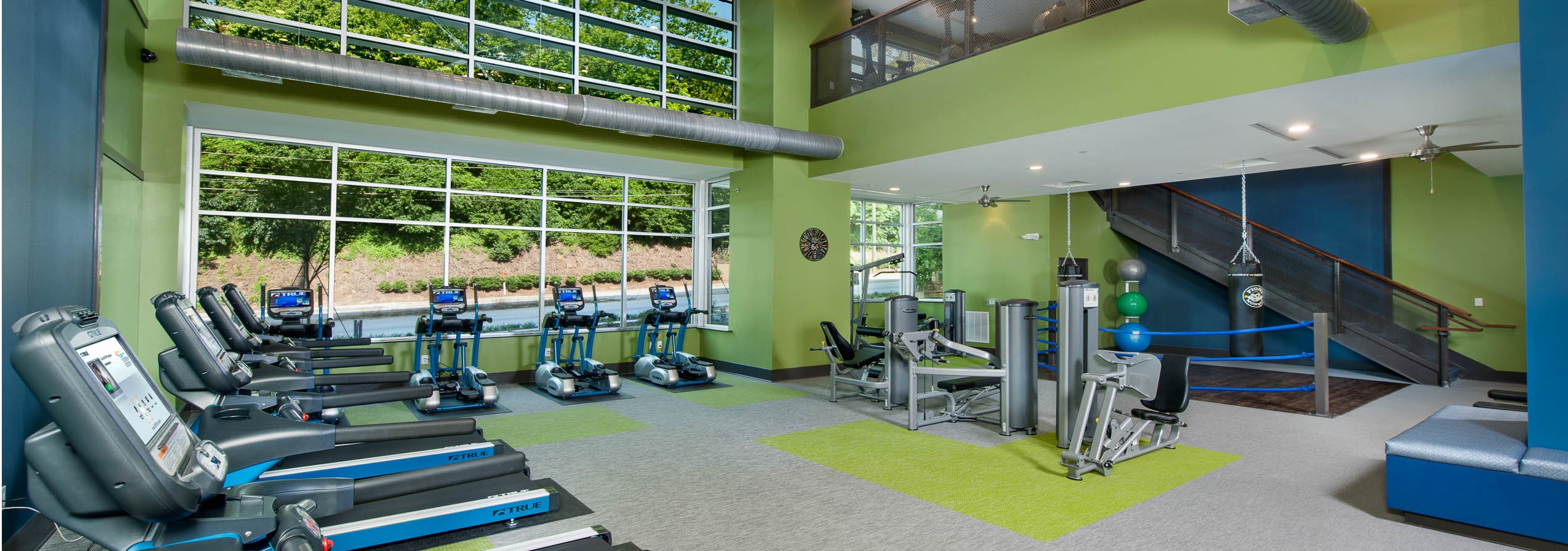 Fitness center at AMLI Piedmont Heights apartments with treadmills as well as cardio and strength machines with large windows