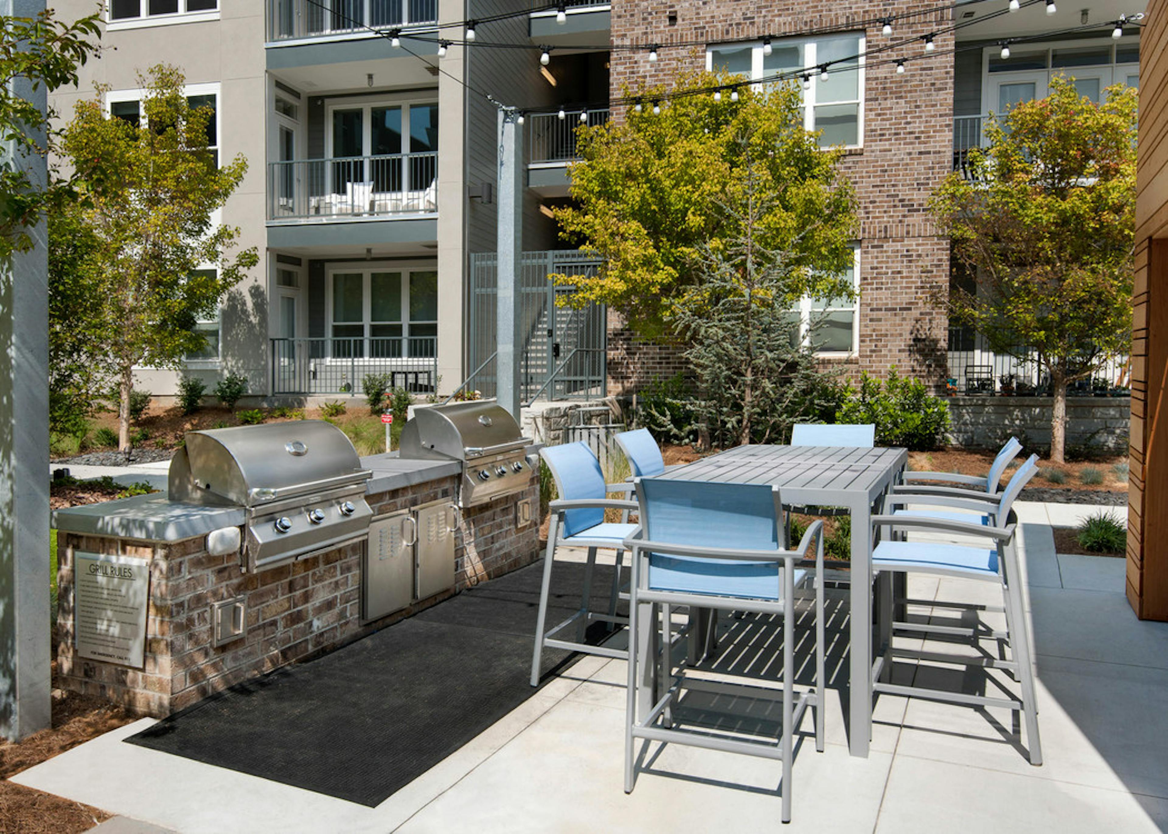 Outdoor grilling area at AMLI Piedmont Heights with stainless steel grill and counter space for food prep with high top table