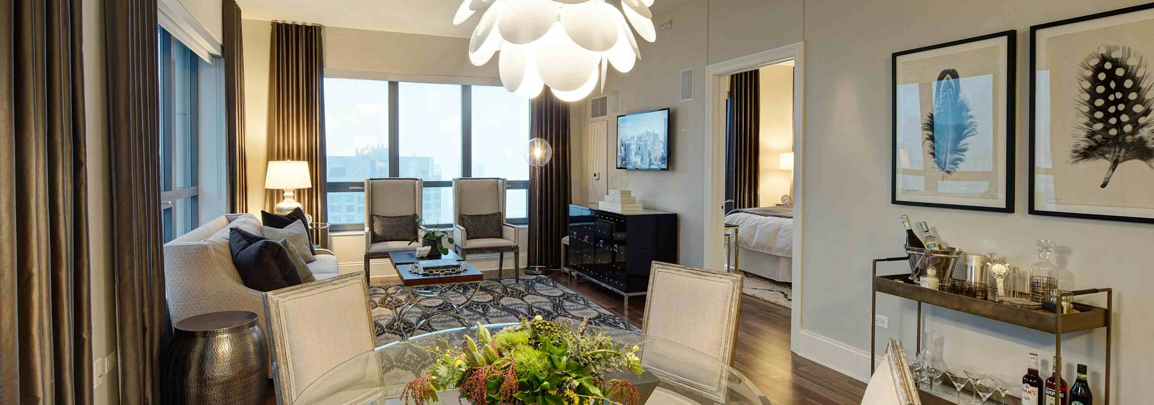 AMLI River North penthouse living room with multiple windows bringing in natural light with wood floors with vintage decor
