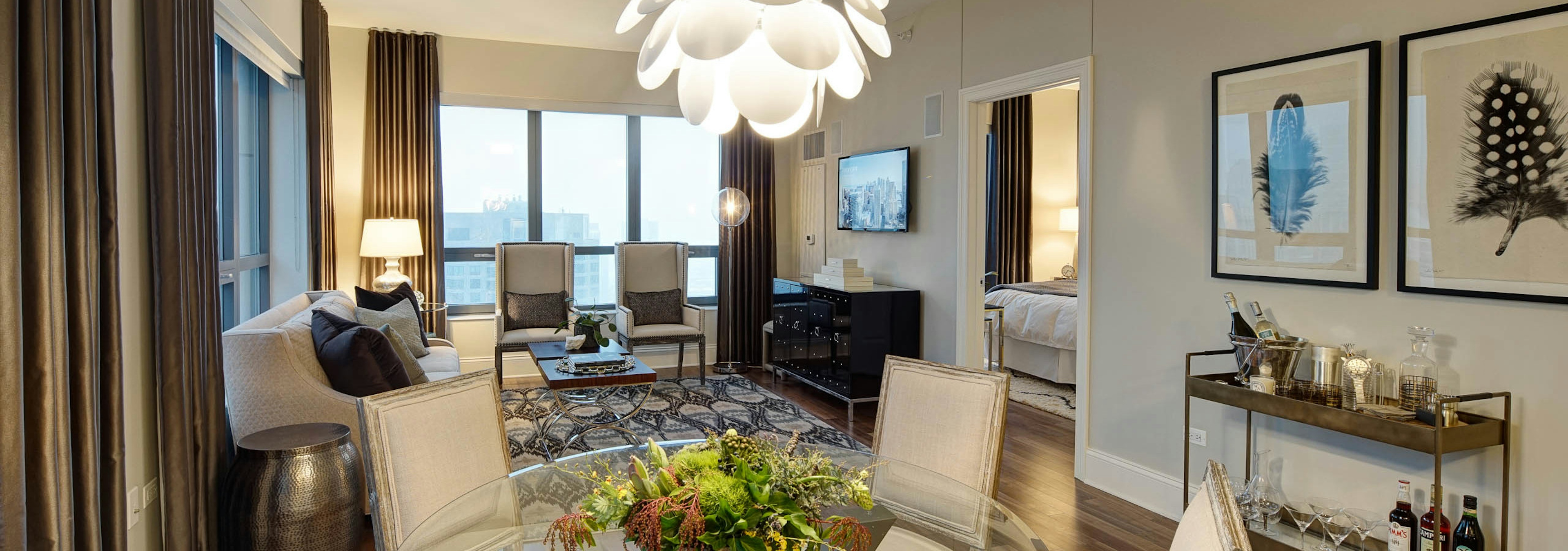 AMLI River North penthouse living room with multiple windows bringing in natural light with wood floors with vintage decor