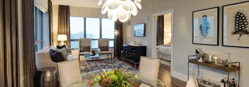 AMLI River North penthouse living room with multiple windows bringing in natural light with wood floors with vintage decor