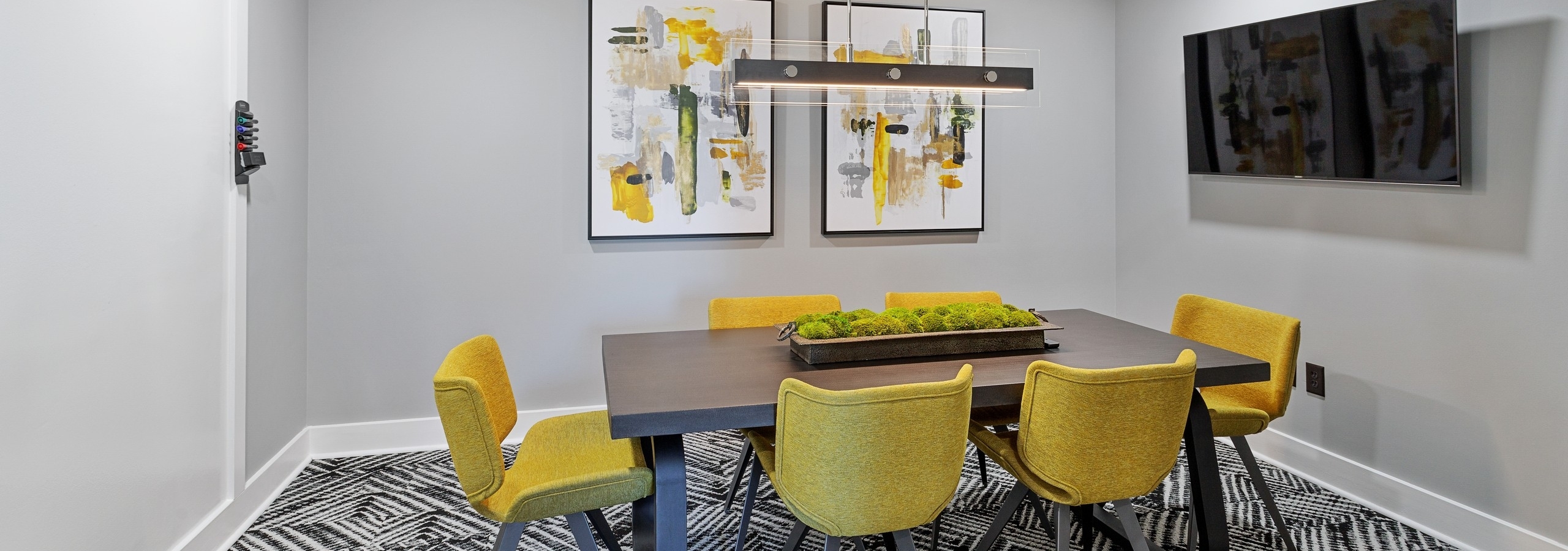 AMLI Parkside conference room with brown table and 6 mustard chairs and abstract art on the wall and hanging light fixture