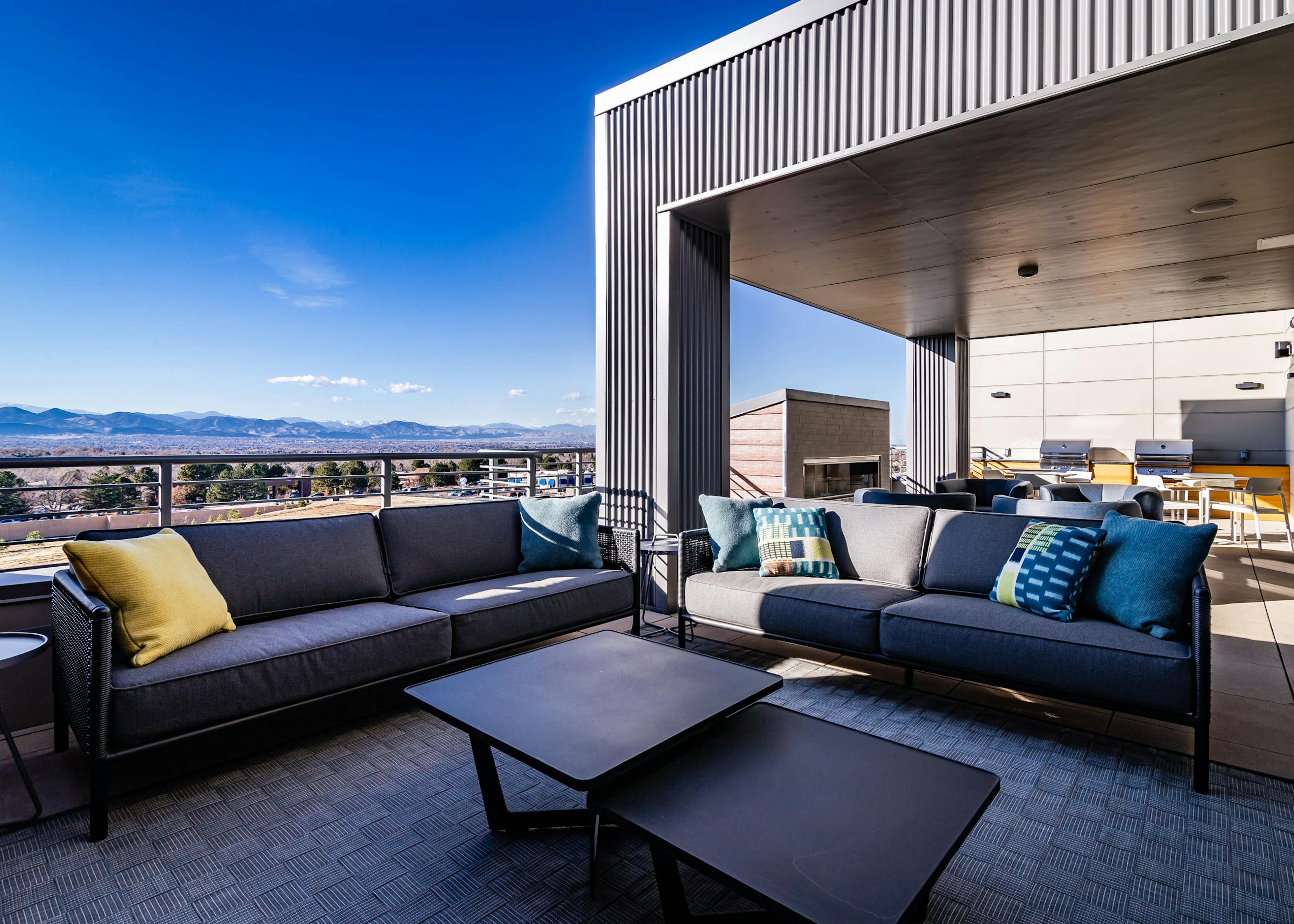 Daytime view of Rooftop outdoor lounge with fireplace, grilling station and cozy seating at AMLI Littleton Village apartments