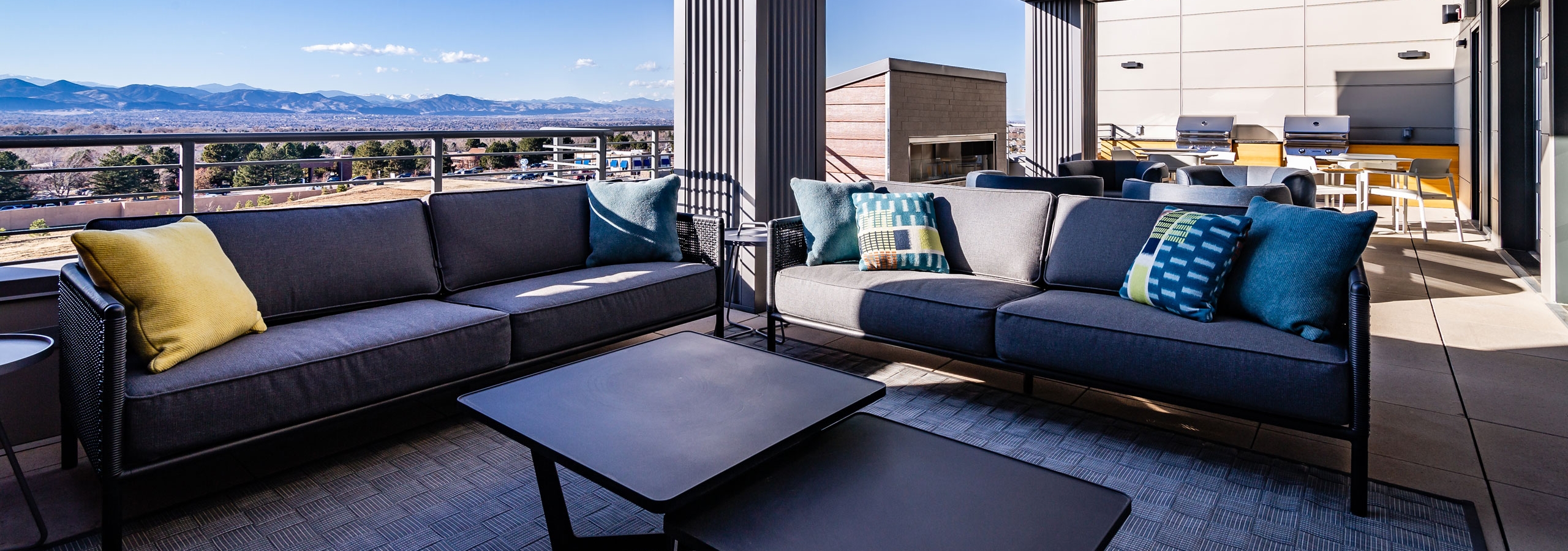 Daytime view of Rooftop outdoor lounge with fireplace, grilling station and cozy seating at AMLI Littleton Village apartments