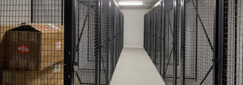 Interior view of large black storage cages on each side of the room with one containing boxes at AMLI Deerfield