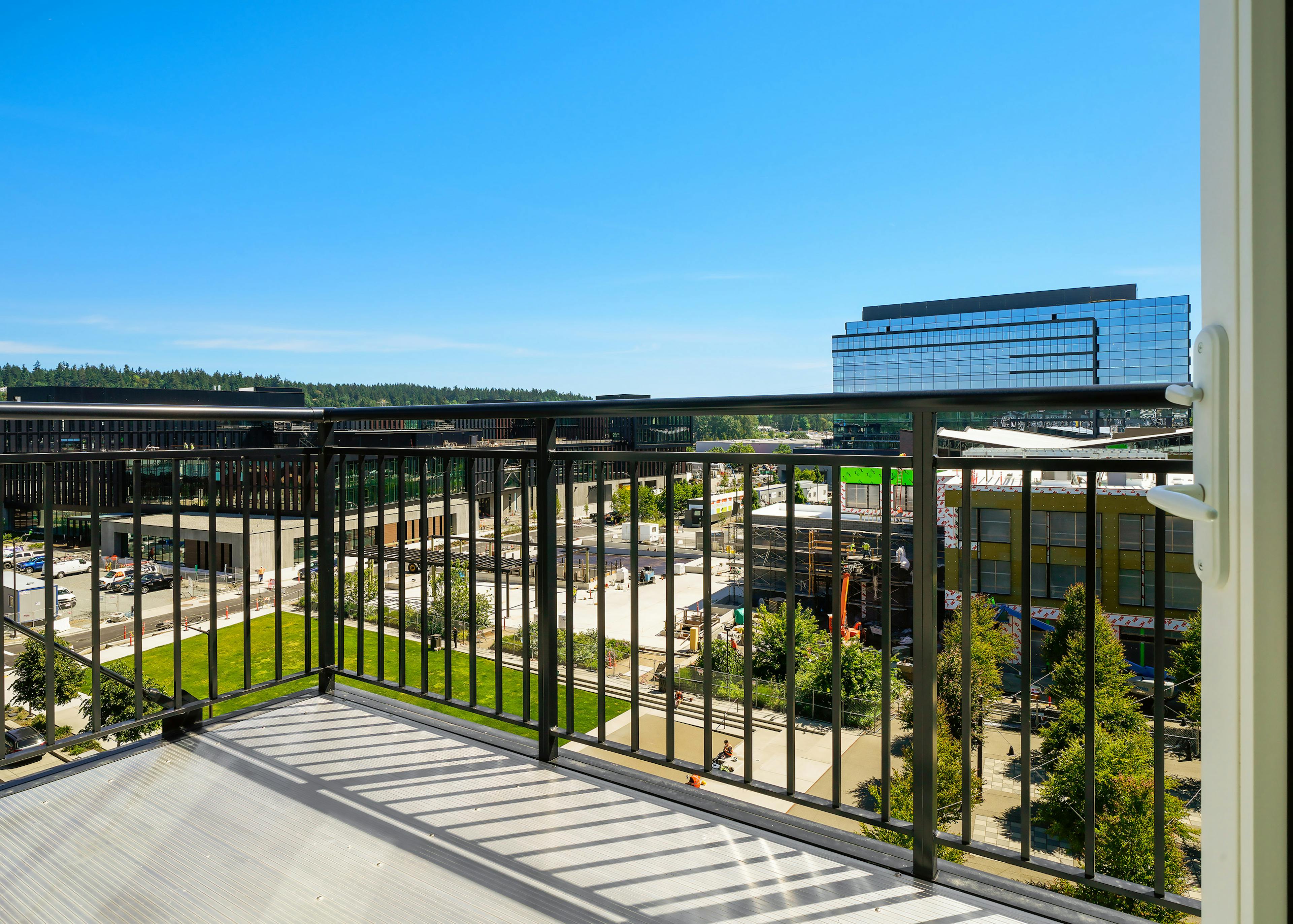 View of the Spring District from an apartment balcony with brown railings at AMLI Spring District on a beautiful sunny day