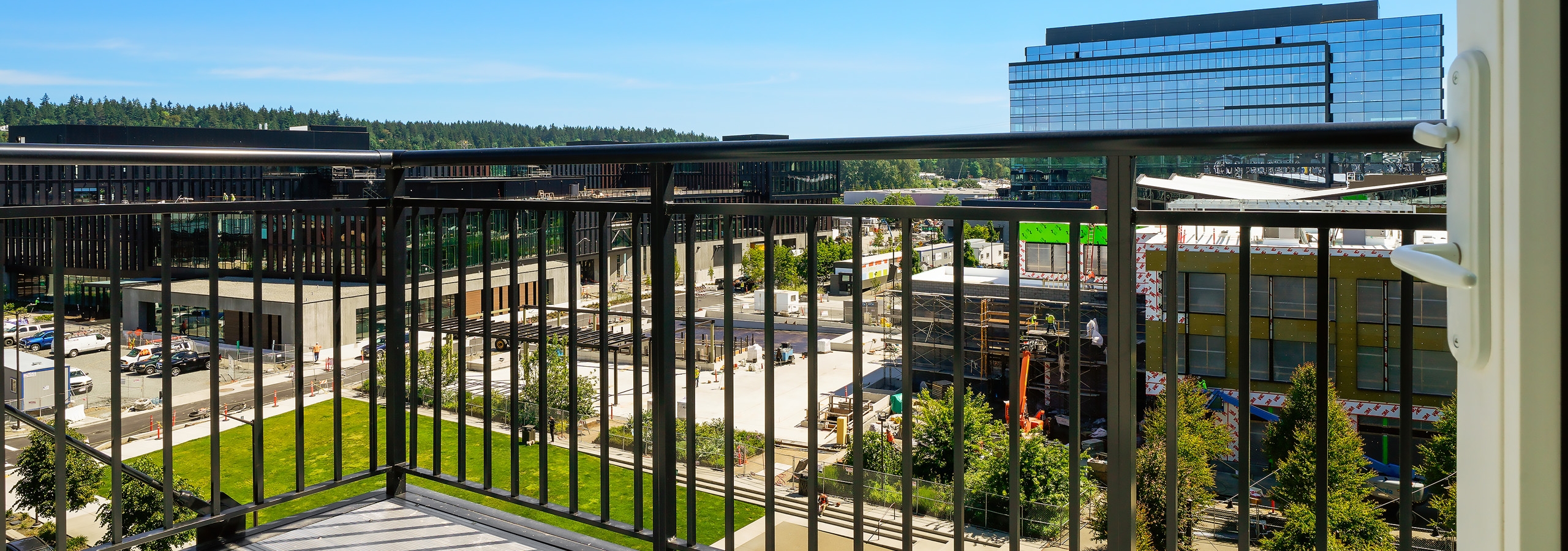 View of the Spring District from an apartment balcony with brown railings at AMLI Spring District on a beautiful sunny day