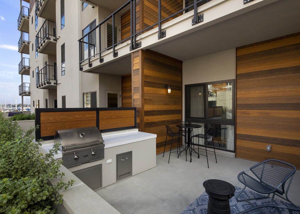 Daytime exterior view of large private patio with wood paneling, attached grilling station at AMLI Marina Del Rey apartments