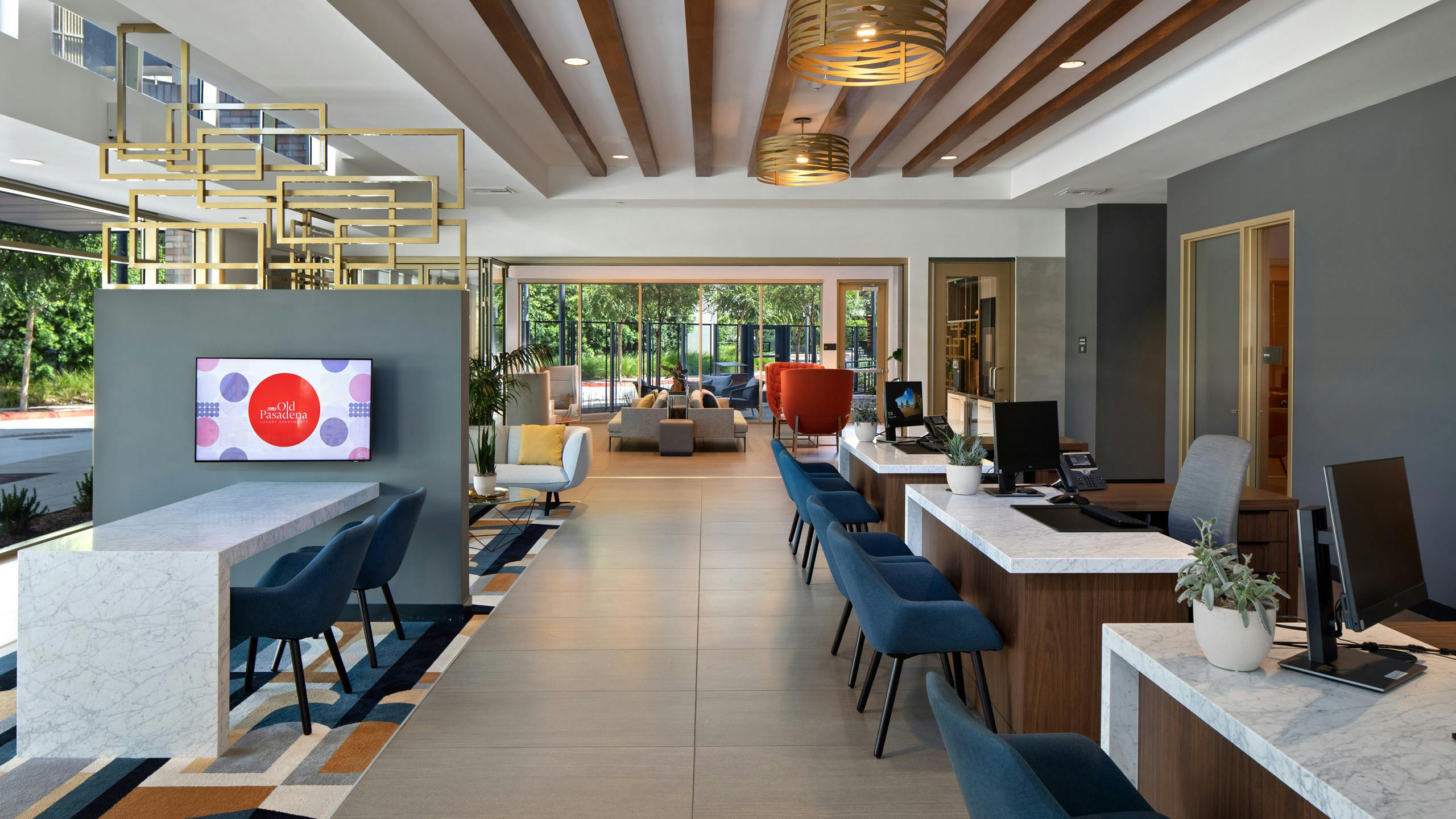 AMLI Old Pasadena leasing office with stylish décor and big screen TV and three white desks with blue guest chairs