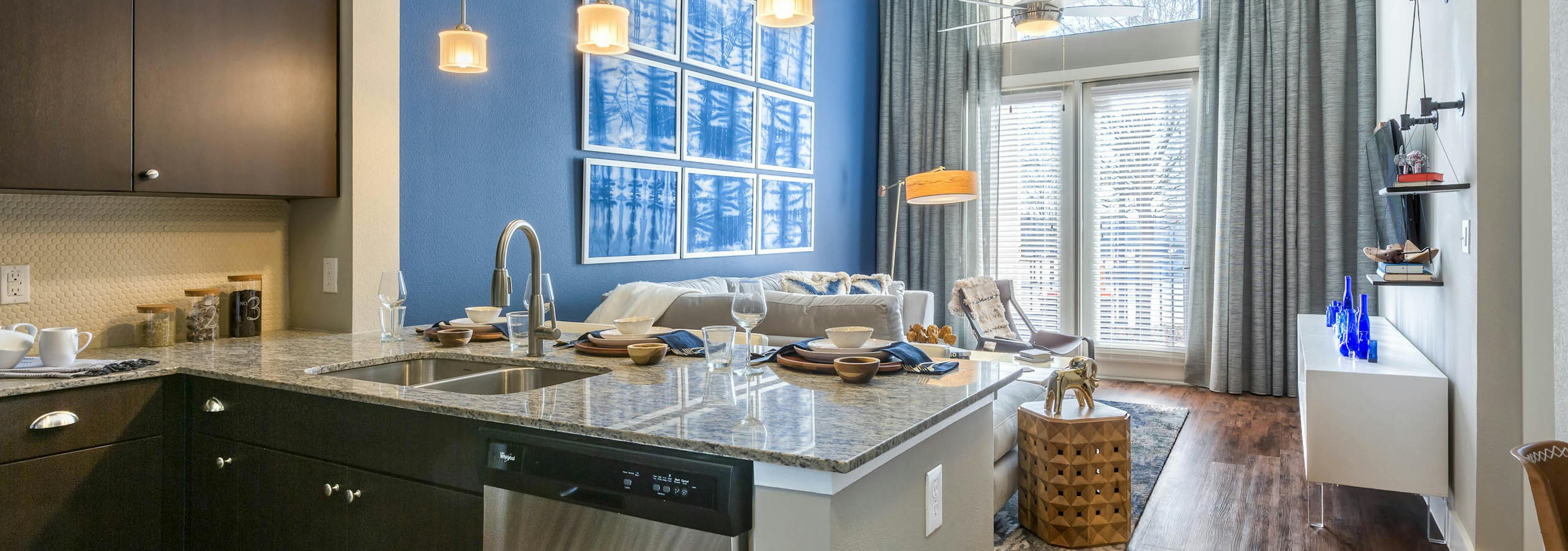 Interior of kitchen at AMLI on Riverside with spacious counter connecting to living space with tall glass balcony doors