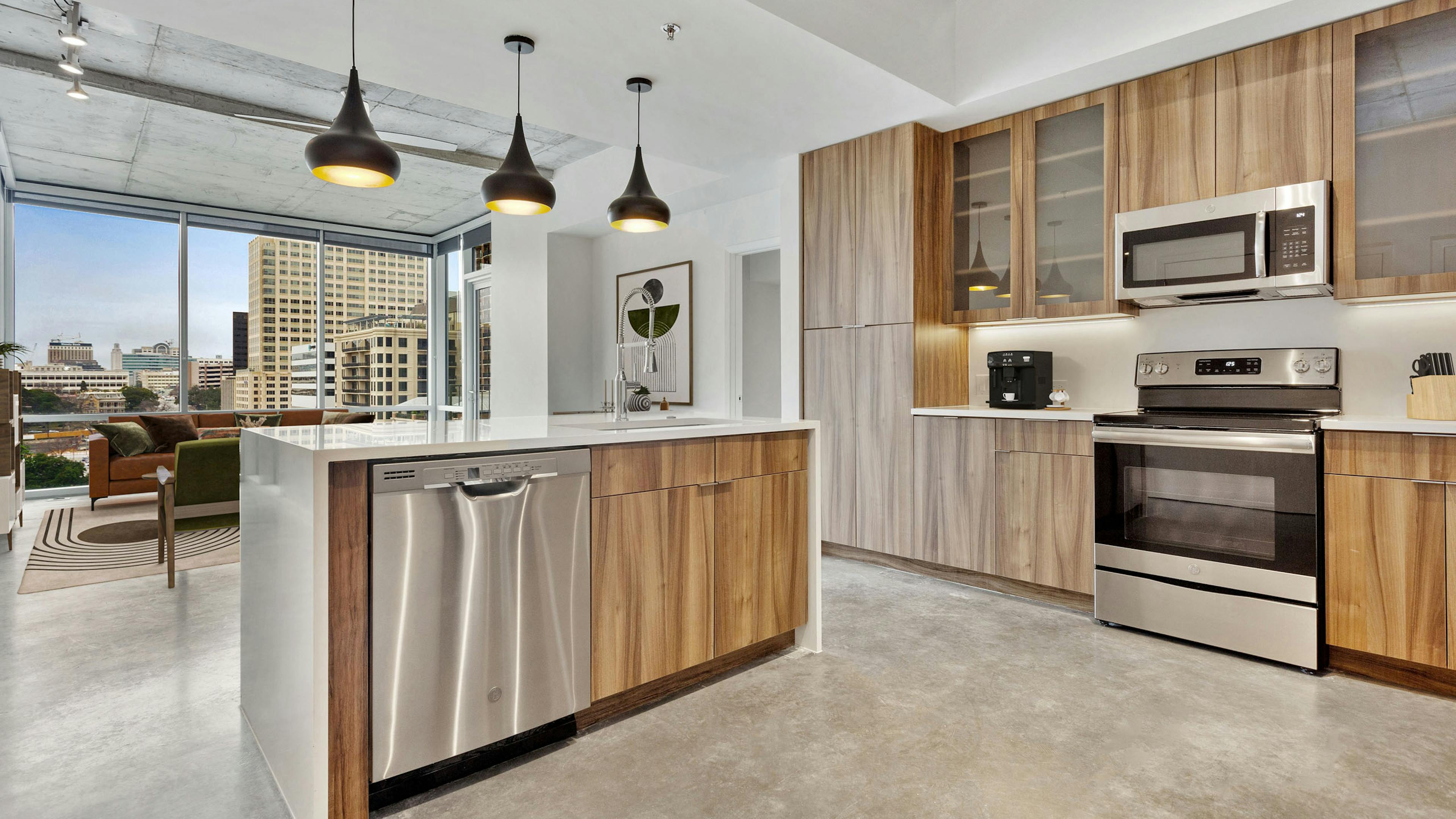 AMLI on 2nd kitchen with stainless steel appliances and white quartz countertops and wood cabinetry with view of living room