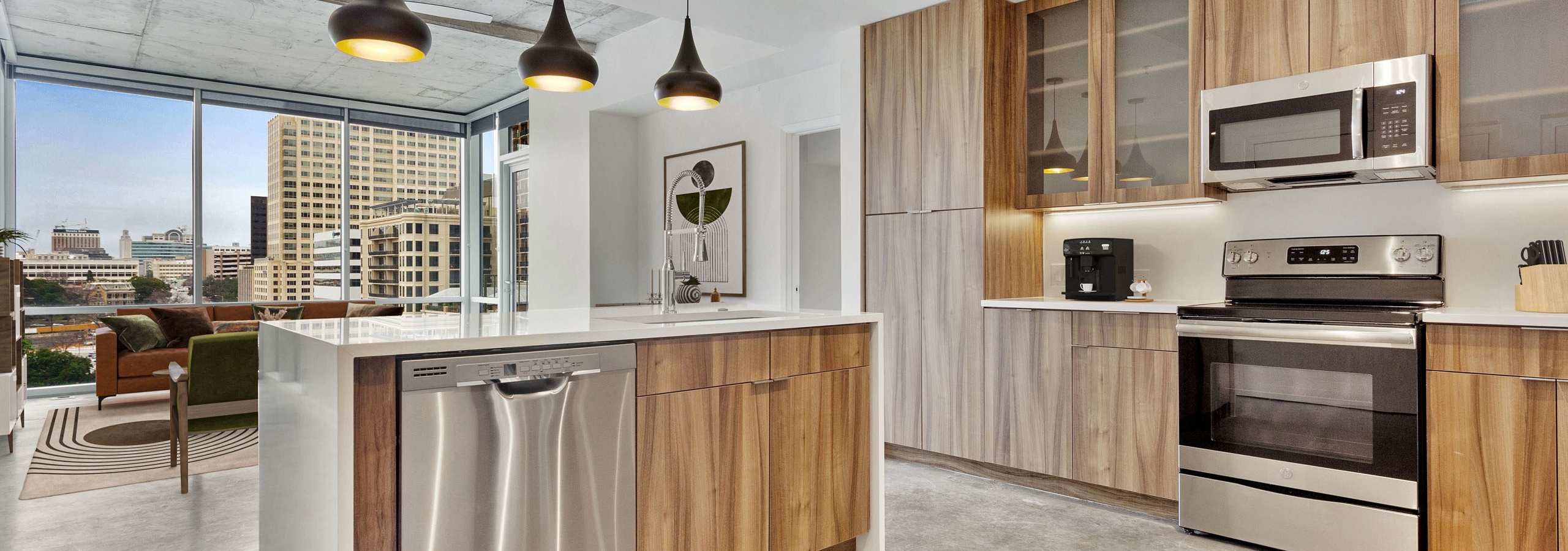 AMLI on 2nd kitchen with stainless steel appliances and white quartz countertops and wood cabinetry with view of living room