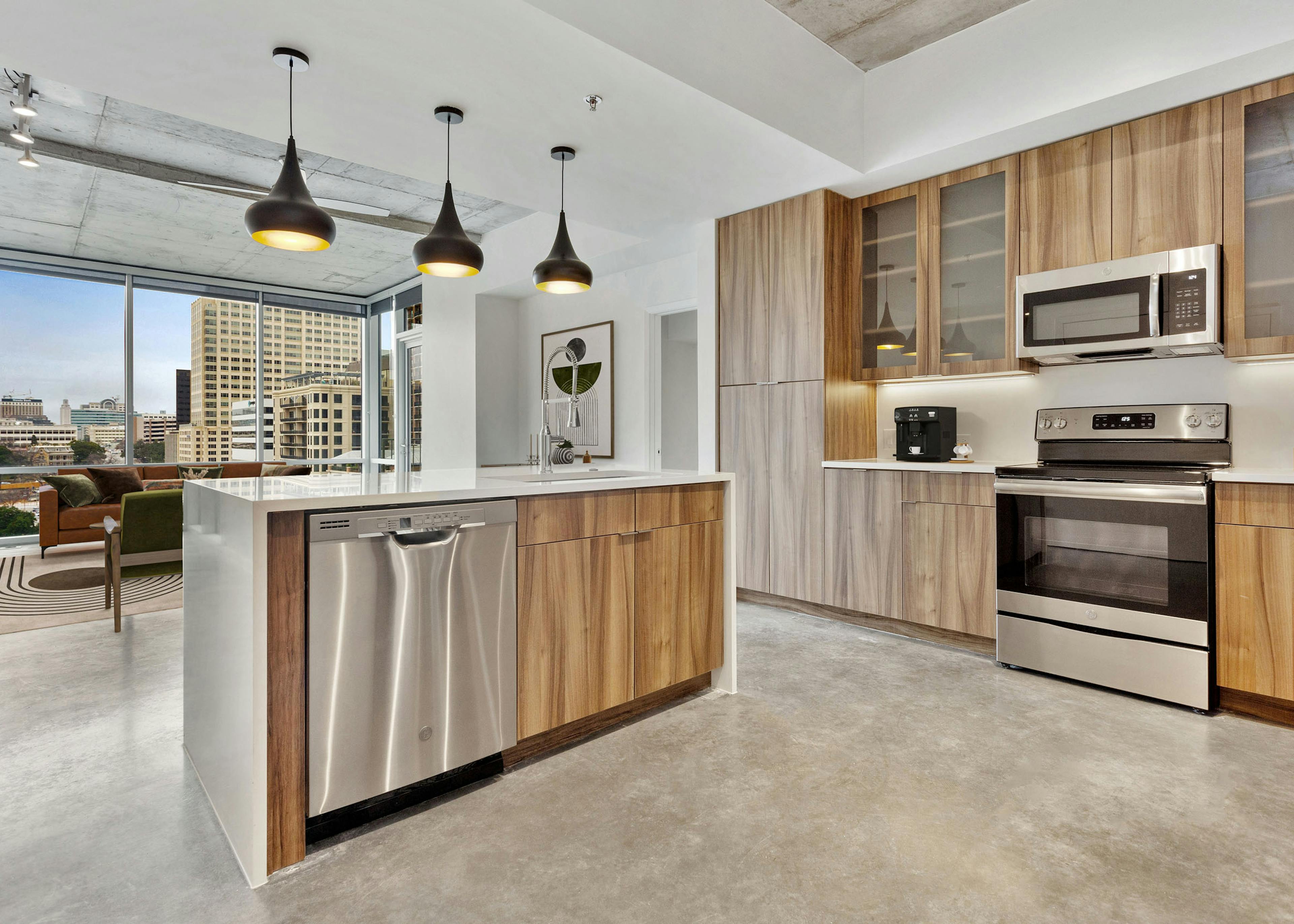 AMLI on 2nd kitchen with stainless steel appliances and white quartz countertops and wood cabinetry with view of living room