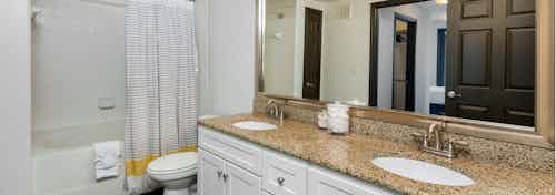 AMLI 300 apartment spa-inspired bathroom with double vanity, an over-sized soaking tub, and elegant granite counter-tops