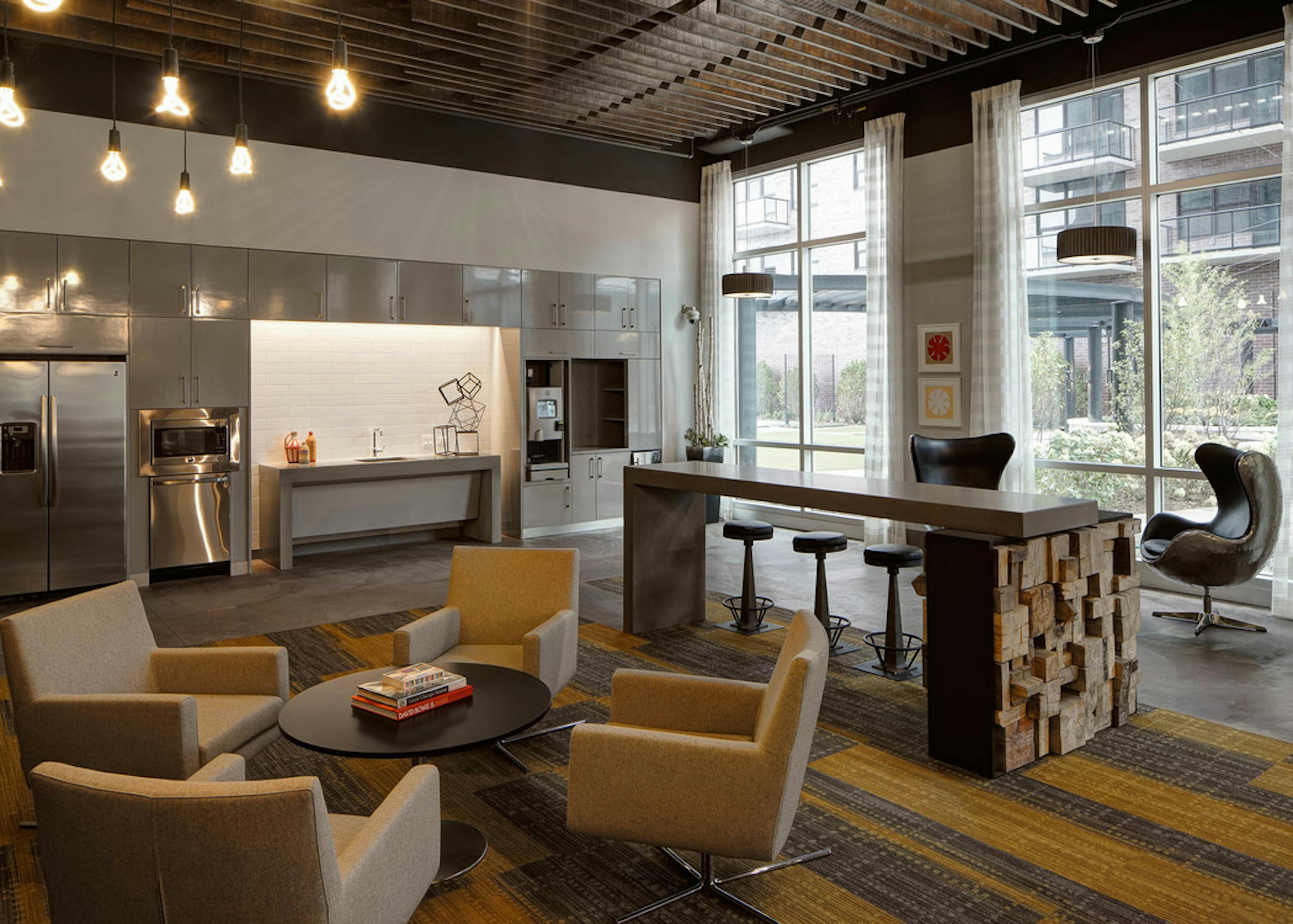 Clubroom at AMLI Lofts with large windows providing city views and a kitchenette with stainless steel appliances and coffee
