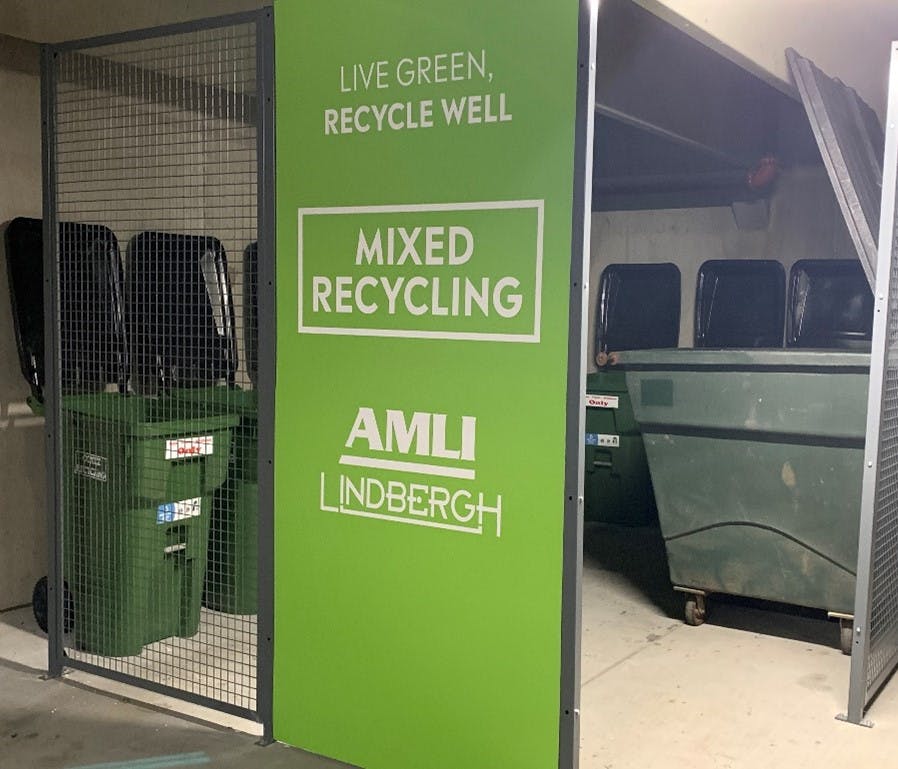 Mixed recycling area at AMLI Lindbergh containing several green recycling bins