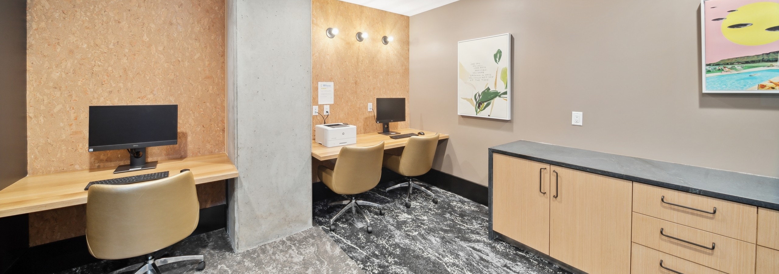 AMLI RiNo business center with wood counter top desks and tan leather chairs and wood credenza and grey veined flooring